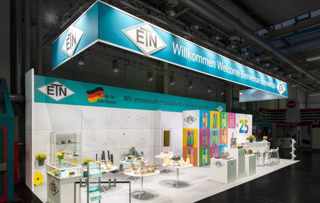 ETN Messestand mit „Willkommen“ Banner und Produktmustern – Interlift Augsburg Messebau.