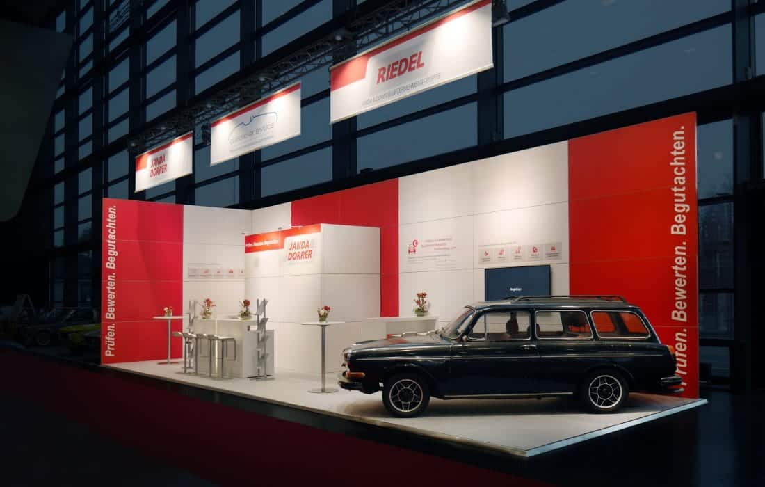 Janda Dorrer und Riedel auf der Retro Classic – stilvoller Messestand mit Oldtimer, rotem Messebau Nürnberg Design.
