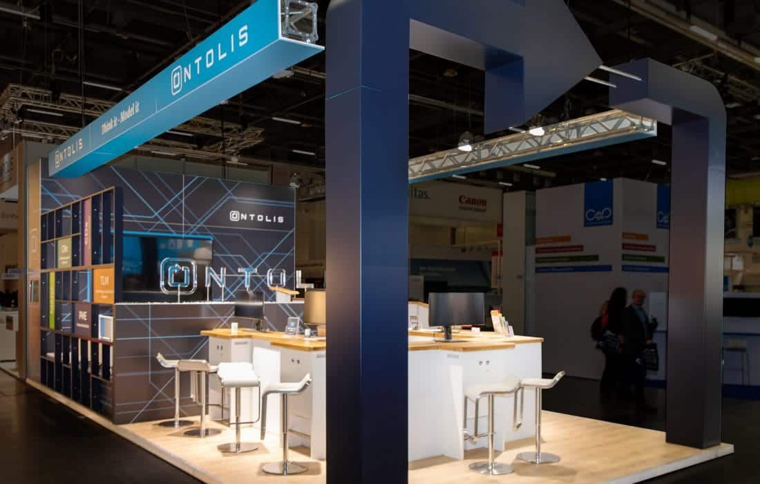 Moderner Messestand von Ontolis auf der ICS Messe in Stuttgart mit offenem Design und Sitzgelegenheiten.