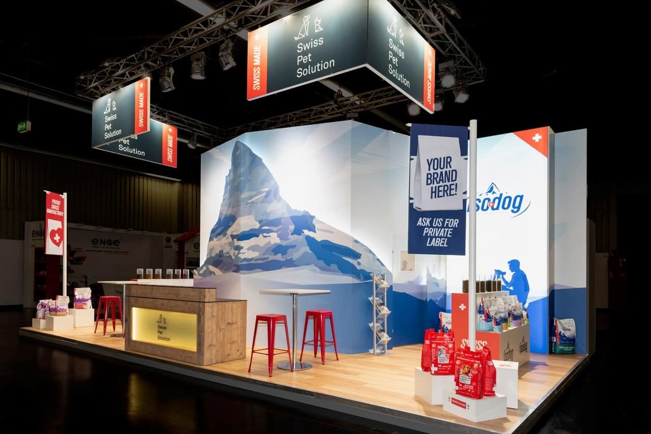 Messebau Nürnberg – Inzerzoo Stand mit Bergmotiv, Swiss Pet Solution Branding und Produktpräsentation.