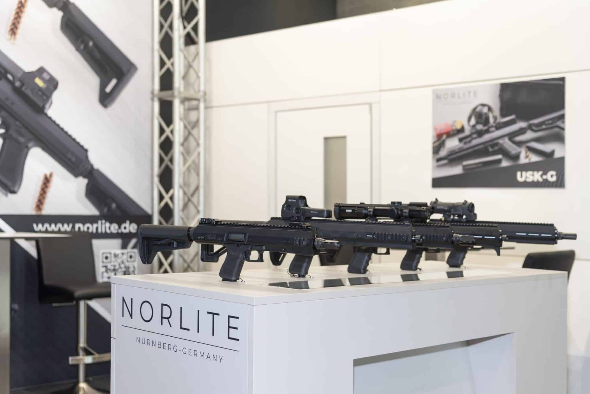 Vorderansicht des Norlite Messestands auf der IWA OutdoorClassics Nürnberg mit großem Banner der USK-G Waffen-Umrüstsätze.