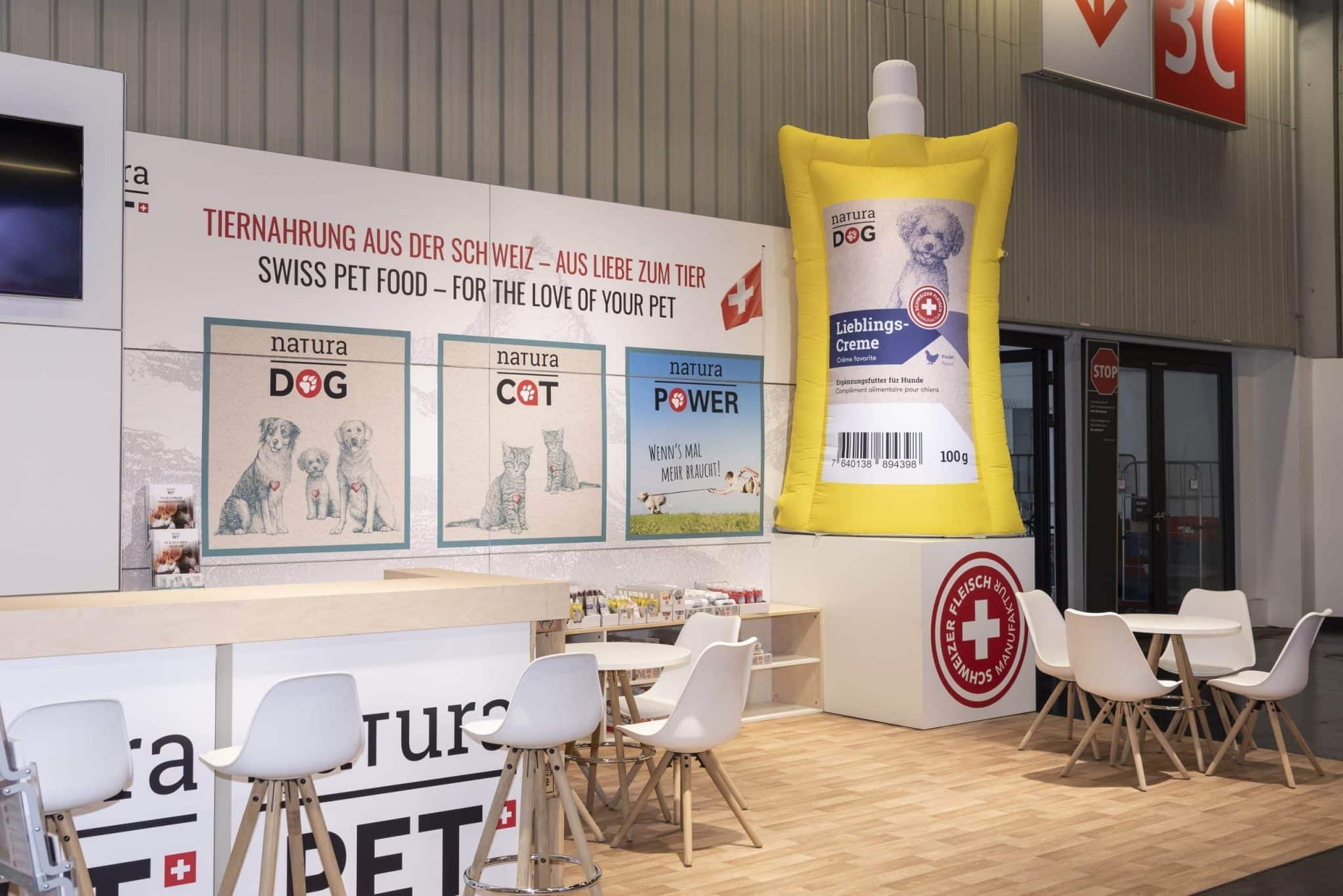 Messestand von NaturaPet auf der Interzoo in Nürnberg mit großen Wandgrafiken für Tiernahrung und aufblasbarer Verpackung als Eyecatcher.