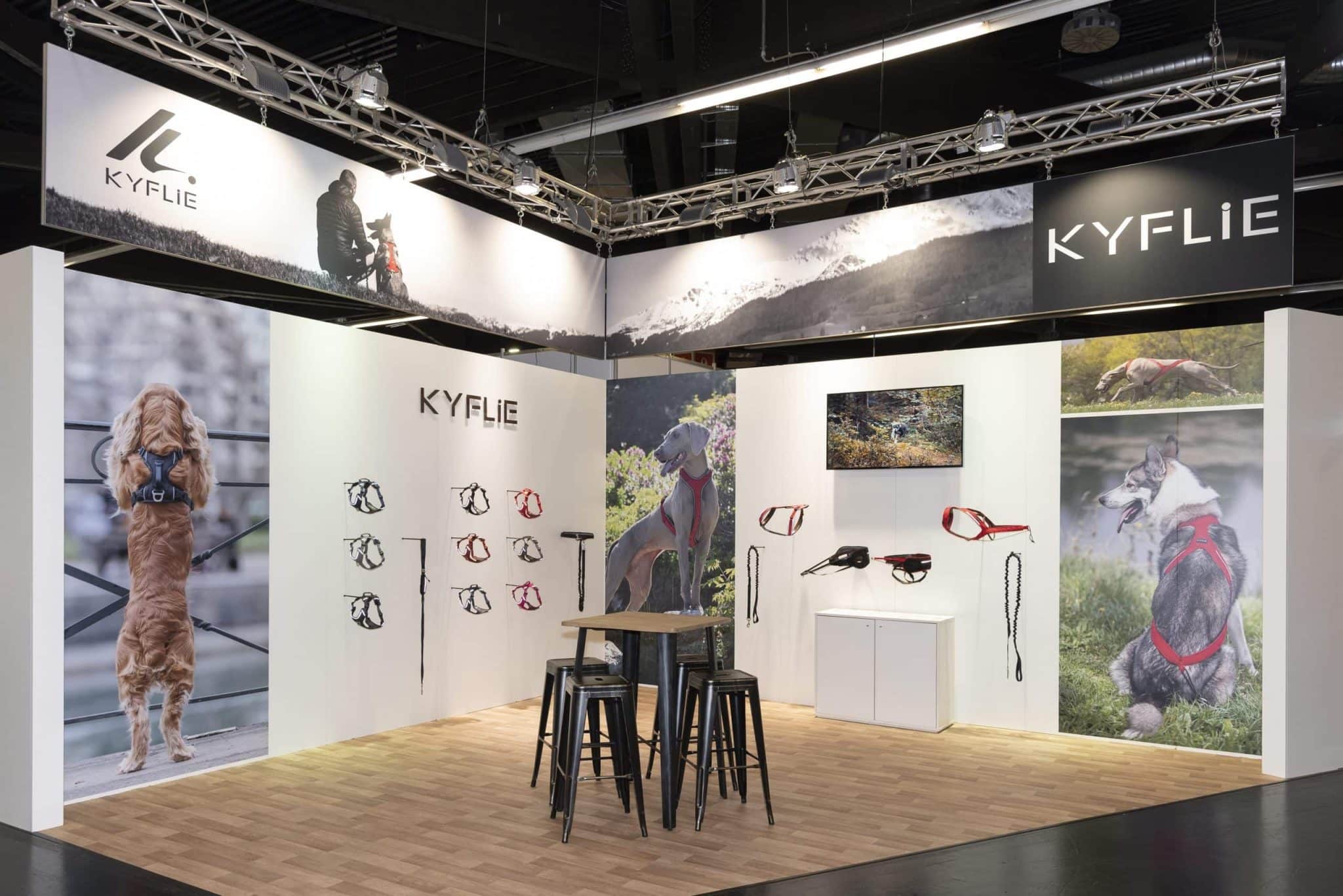 Moderner Messestand von Kyflie auf der Interzoo Nürnberg mit Hundegeschirren, Leinen und großflächigen Wandgrafiken von Hunden in Aktion.