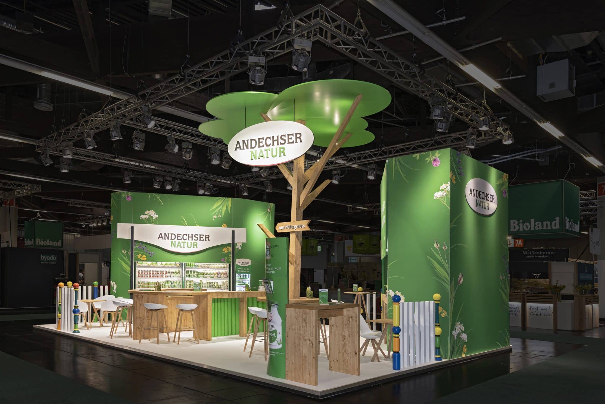 Komplettansicht des Andechser Natur Messestands mit Holzelementen und großem Logo auf der Biofach Nürnberg – Messebau Nürnberg.