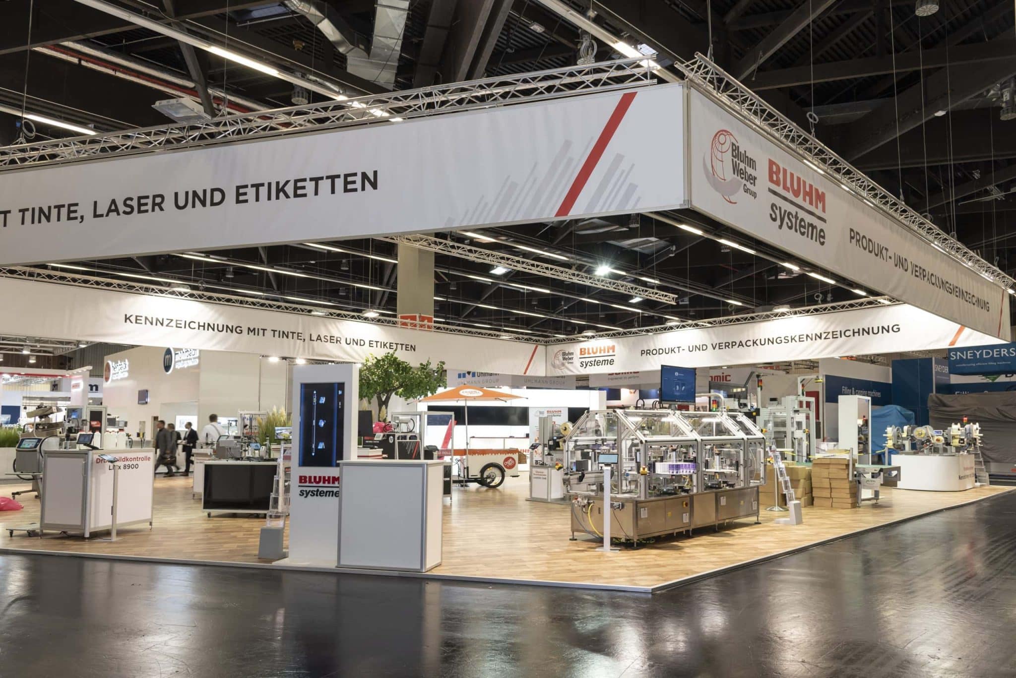 Großer Bluhm Systeme Messestand mit Maschinen zur Verpackungskennzeichnung – Messebau Nürnberg.