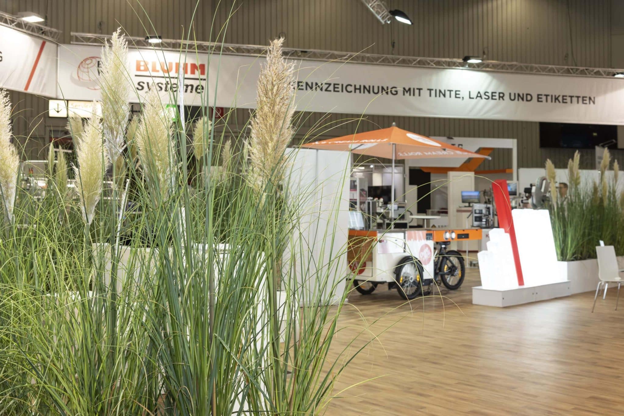Detailaufnahme von Pflanzen-Elementen im Bluhm Systeme Messestand mit Sicht auf die Beschriftungstechnik – Messebau Nürnberg.