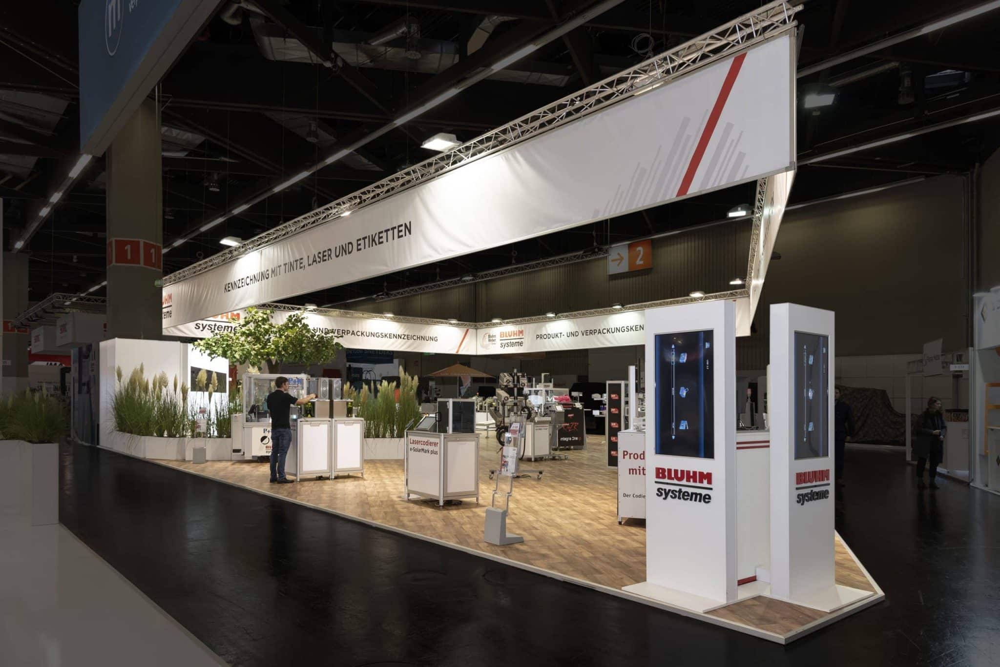 Moderner Messestand von Bluhm Systeme mit Maschinen für Produkt- und Verpackungskennzeichnung – Messebau Nürnberg.