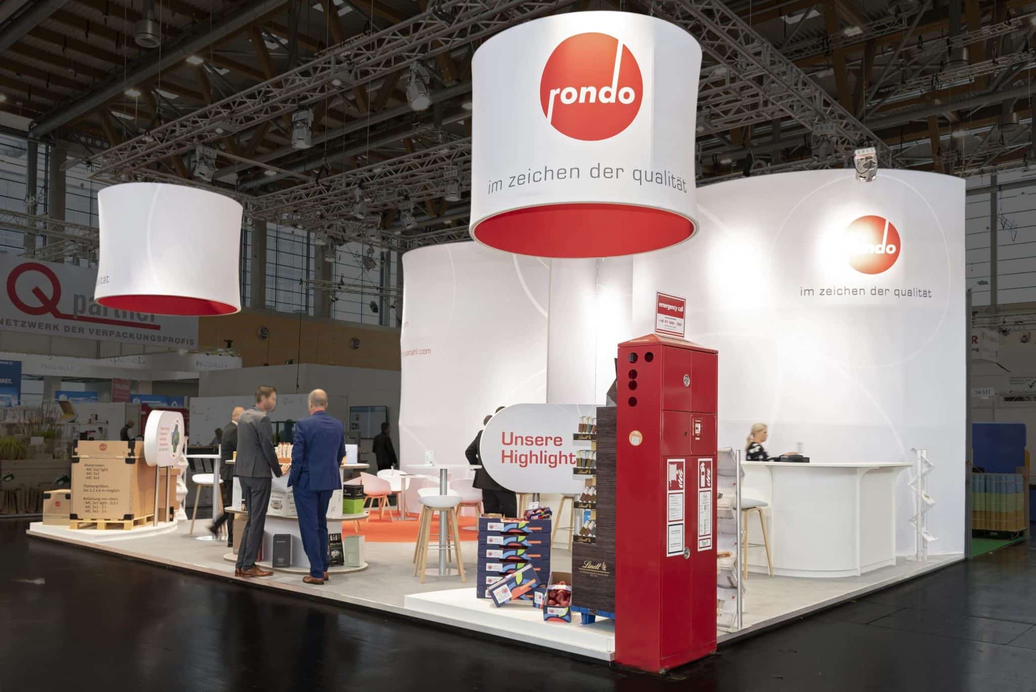 Dekorativer Pappbaum und Präsentationsfläche vor dem Abel Wiesn Stand auf der Fachpack Nürnberg – Messebau Nürnberg.