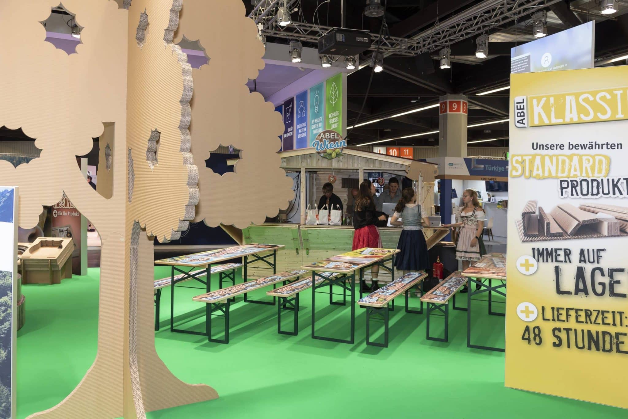 Abel Wiesn Stand mit Pappbaum und Biertischgarnituren auf der Fachpack Nürnberg – Messebau Nürnberg.