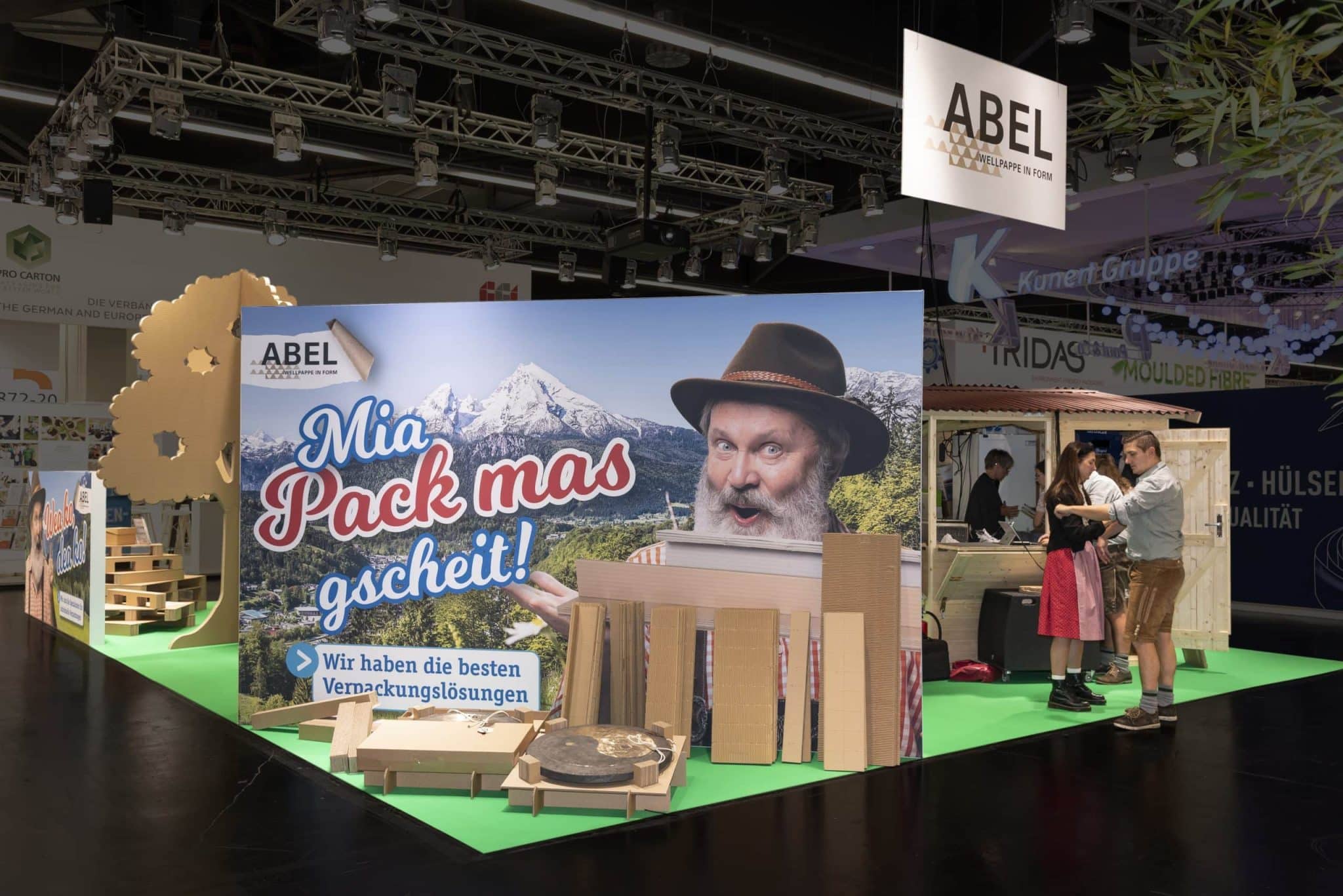 Abel Messestand mit großem Werbebanner „Mia pack mas gscheit“ und nachhaltigen Verpackungslösungen auf der Fachpack Nürnberg – Messebau Nürnberg.