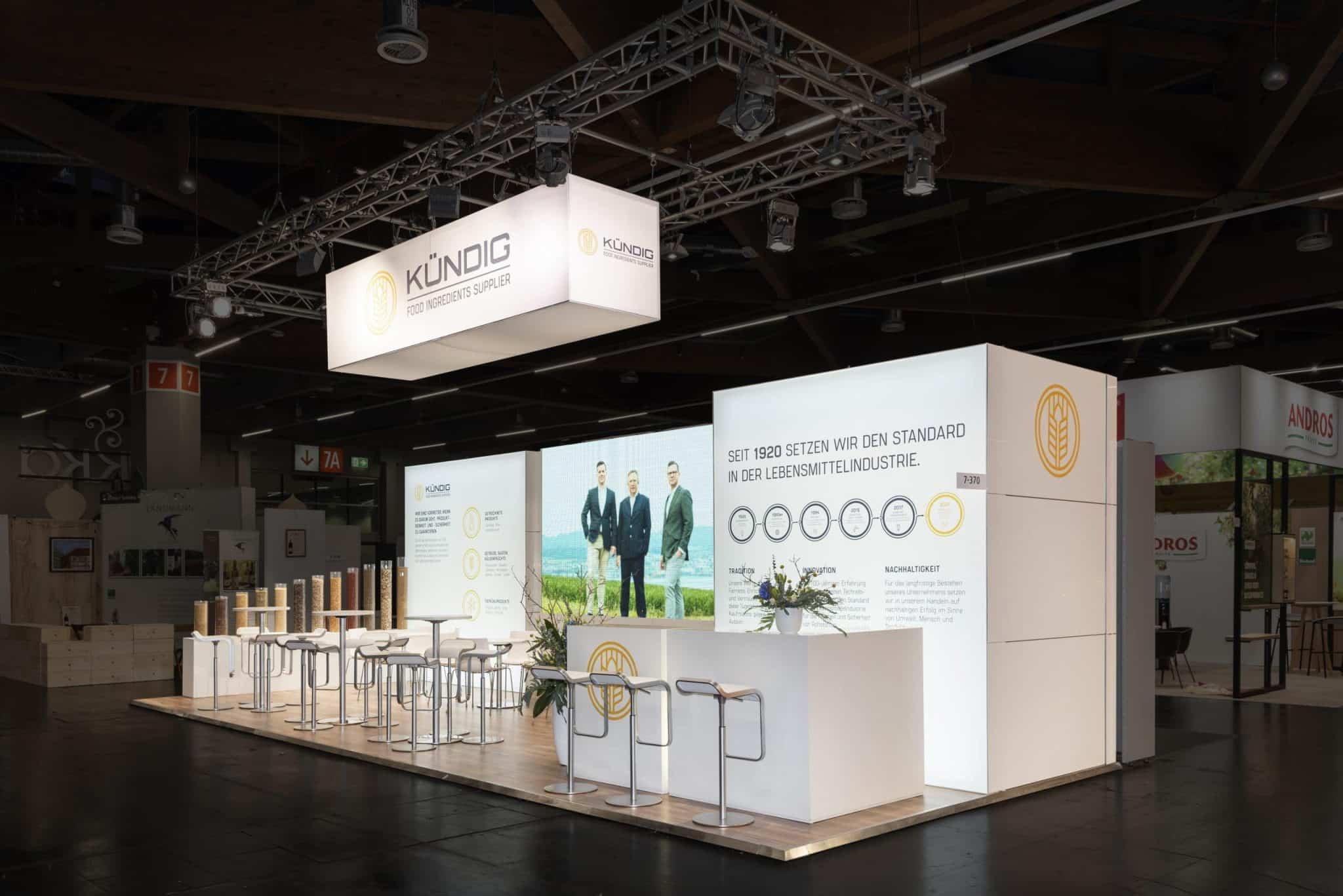 Präsentationsstand von Kündig auf der Biofach Messe 2025 in Nürnberg mit großem Display und nachhaltigem Design.