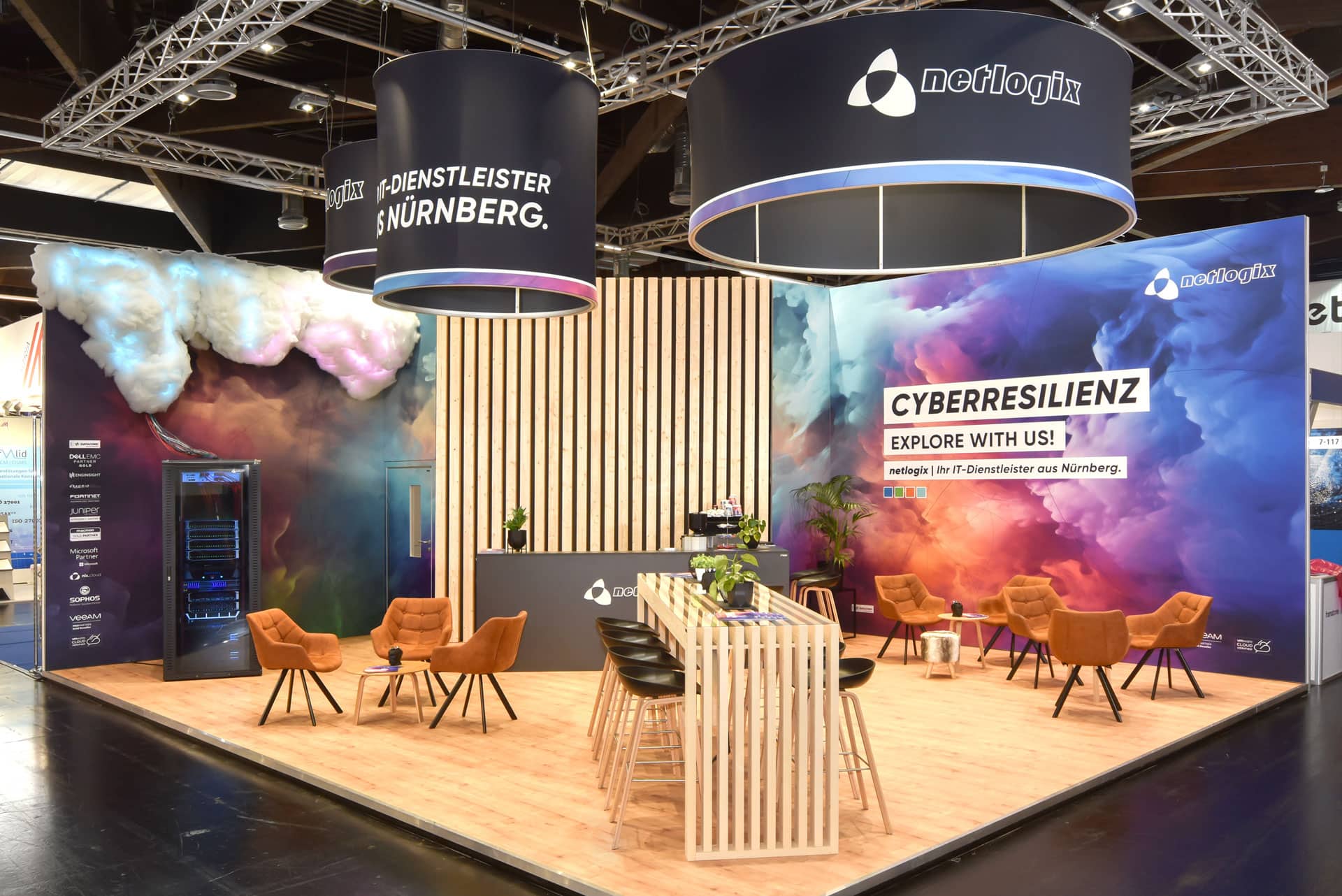 Messestand von Löew Präzisionsteile und Diener & Rapp auf der Medtech Live 2023 mit Glasvitrinen und grün-blauer Rückwand.