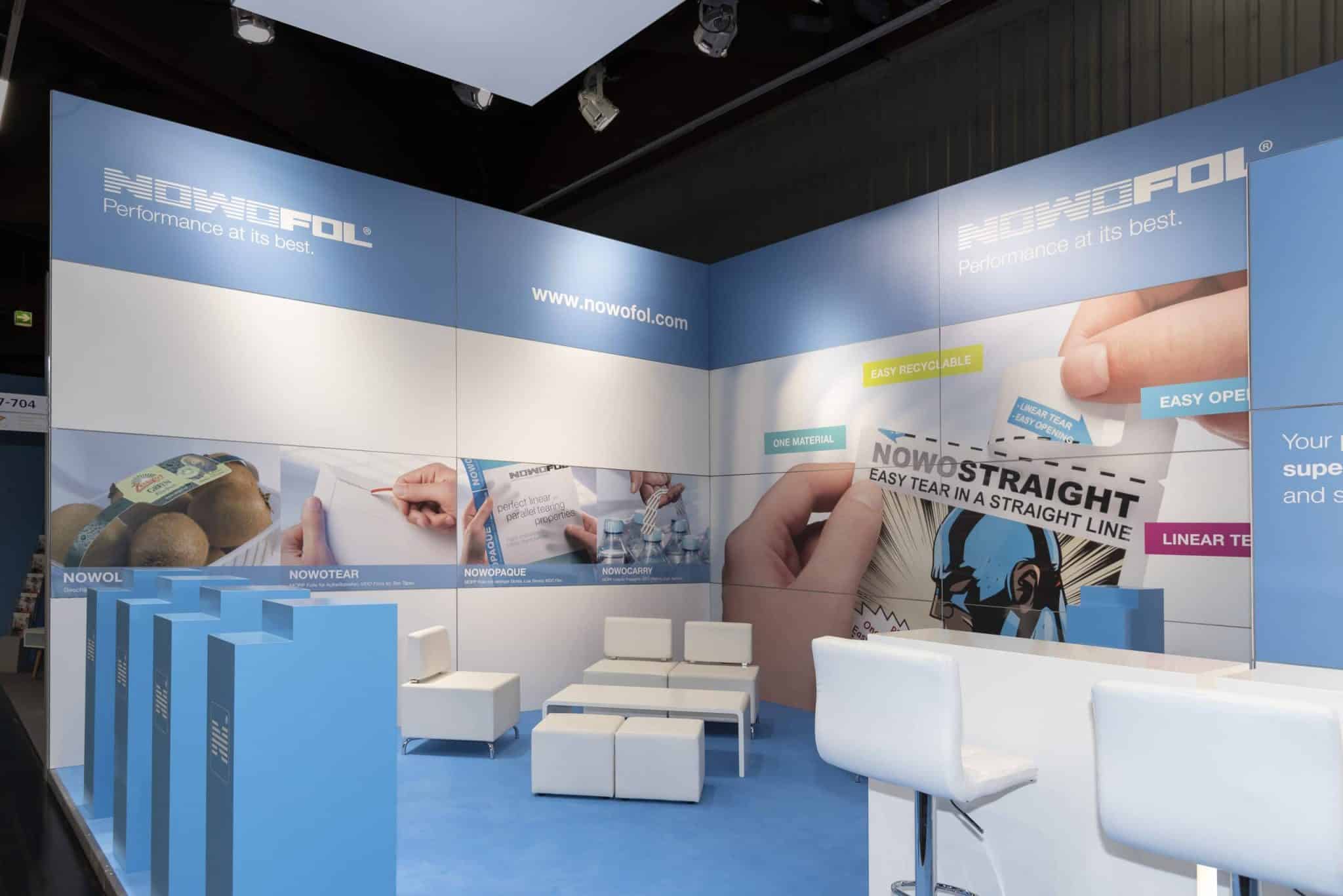 Fachpack Nürnberg Messestand von Nowofol mit Präsentationswänden, Sitzbereich und großem Markenbranding „Messebau Nürnberg“.