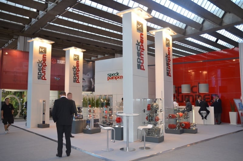 Messestand mit hohen beleuchteten Säulen und Technikexponaten – Speck Pumpen auf der Achema Frankfurt | Messebau Frankfurt