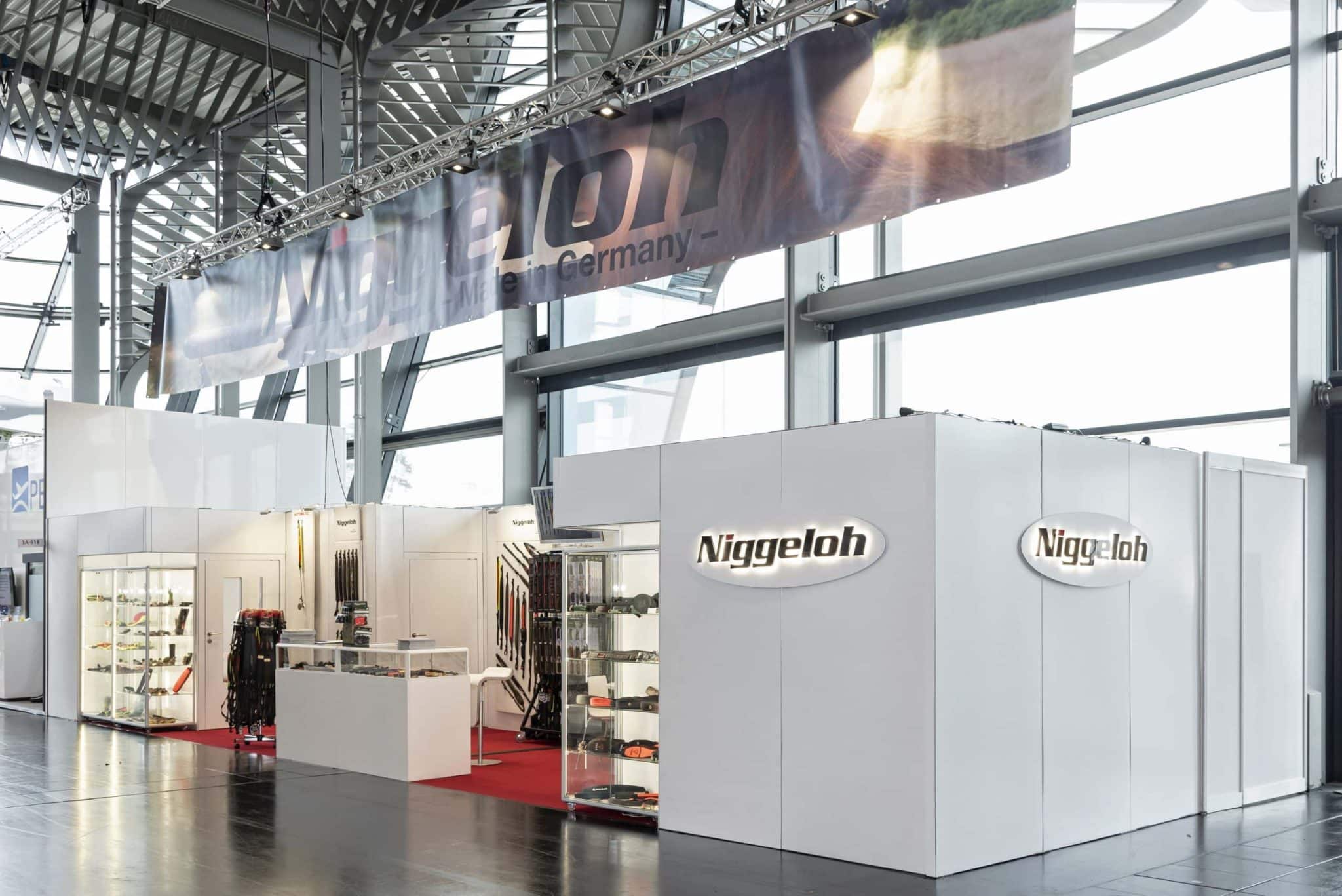 Messebau Nürnberg auf der IWA, Messestand Niggeloh mit großem Logo, Glasvitrinen und modernem Design