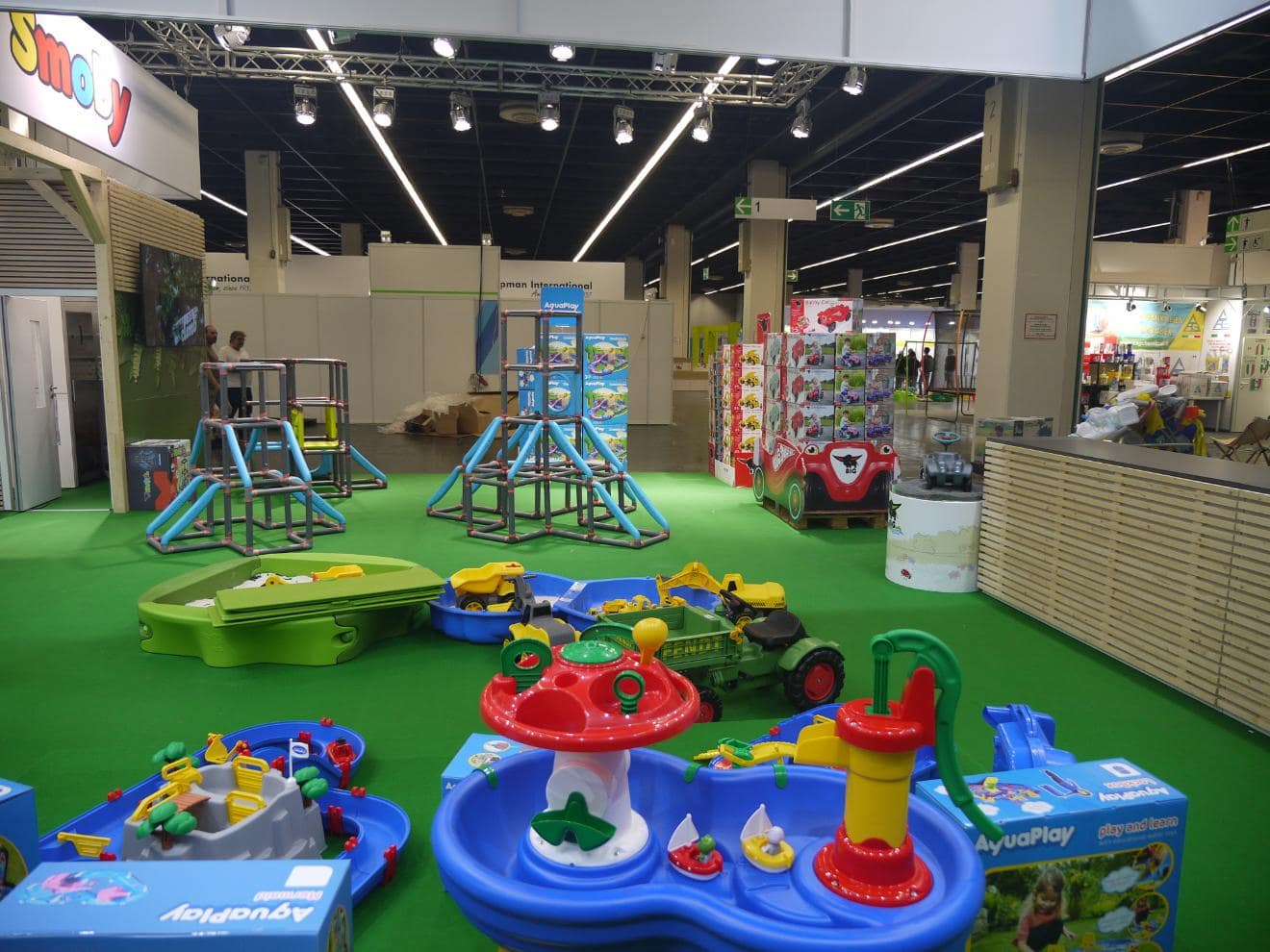 Übersicht des Smoby Messestands mit AquaPlay Wasserspielen, Bobby-Car Kartons und Klettergerüsten auf der spoga+gafa in Köln.