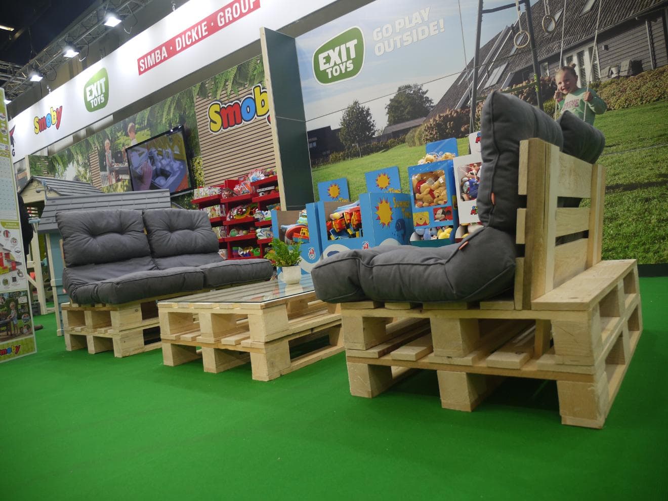 Sitzmöbel aus Paletten mit grauen Polstern am Messestand von EXIT Toys auf der spoga+gafa 2023 in Köln.