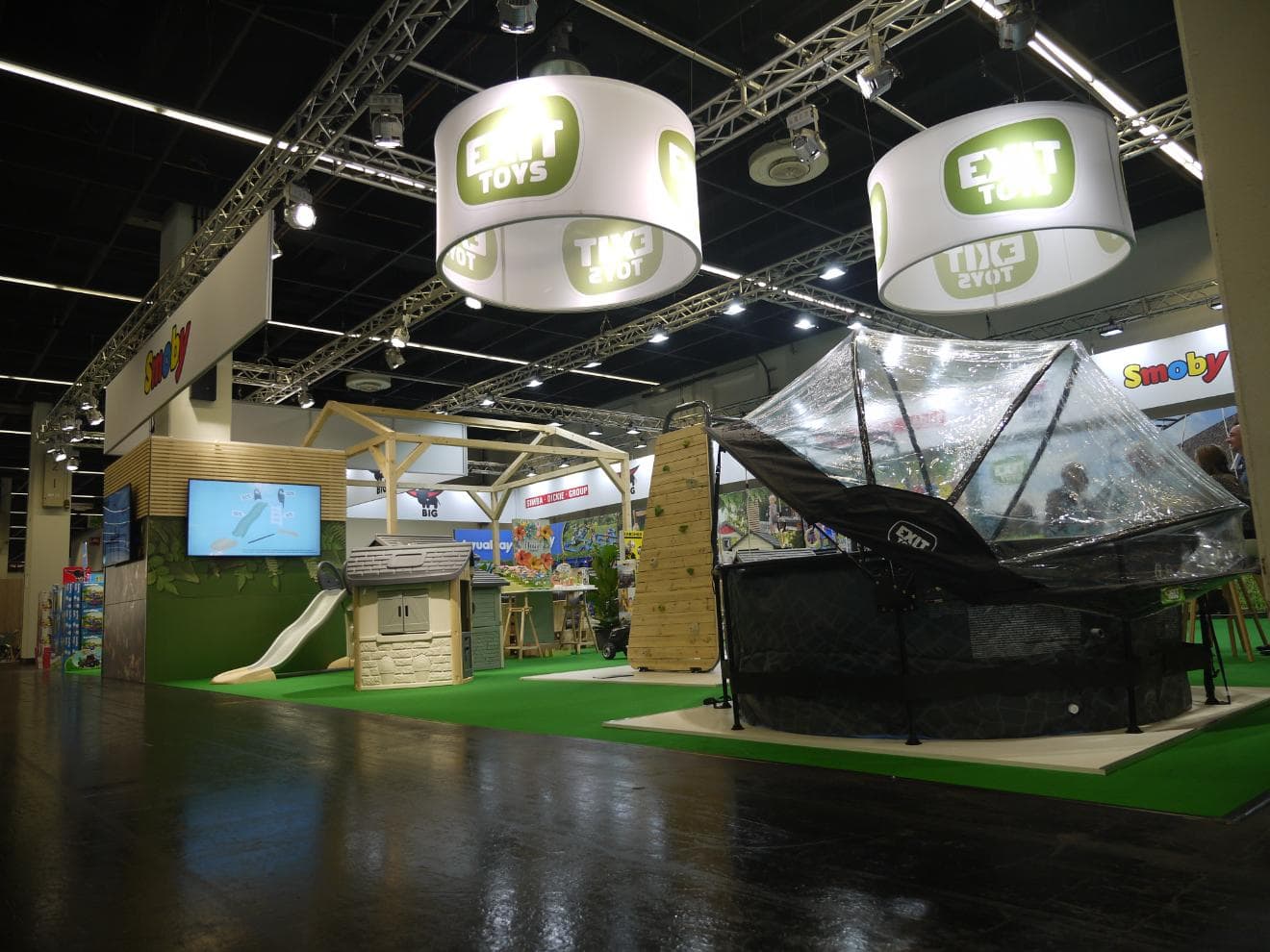 Messestand von EXIT Toys und Smoby auf der spoga+gafa 2023 in Köln mit Pool, Spielhäusern und Kletterwand.