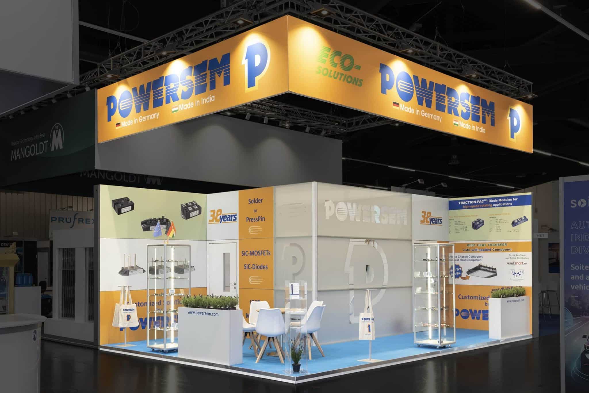 Beleuchteter Powersem Messestand auf der PCIM Nürnberg mit Deckenbanner und Sitzbereich – Messebau Nürnberg