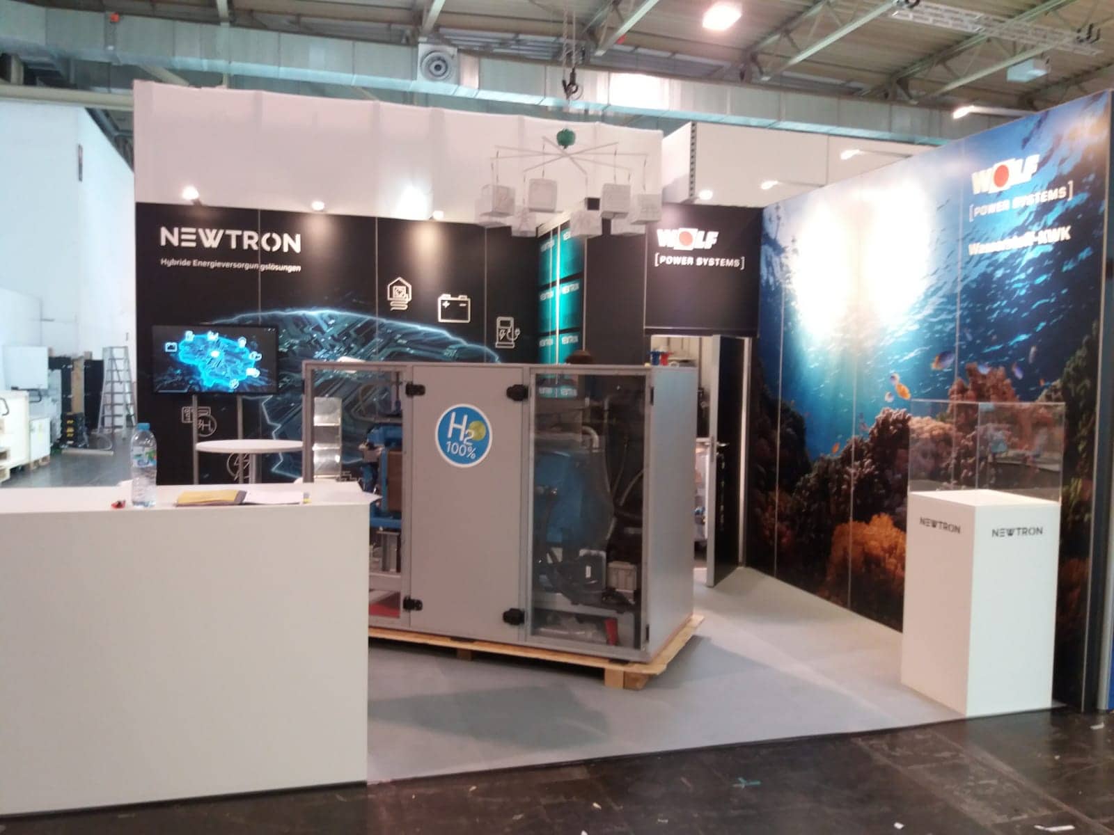 Moderner Messestand von Wolf Power Systems und Newtron auf der E-World in Essen mit H₂-100% Wasserstoff-KWK-Anlage – Messebau Essen