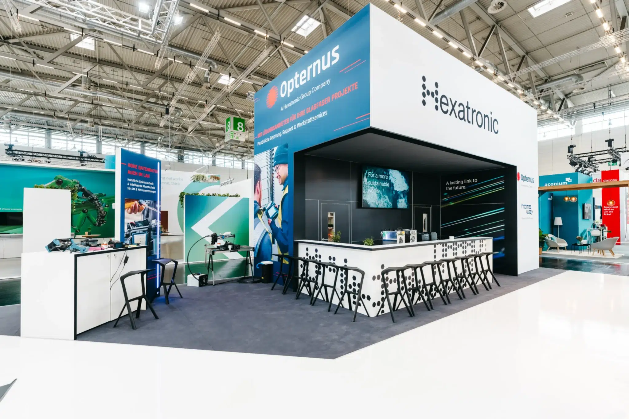 Messestand Köln – Hexatronic und Opternus mit moderner Bar und Beratungstheke auf der Messe.
