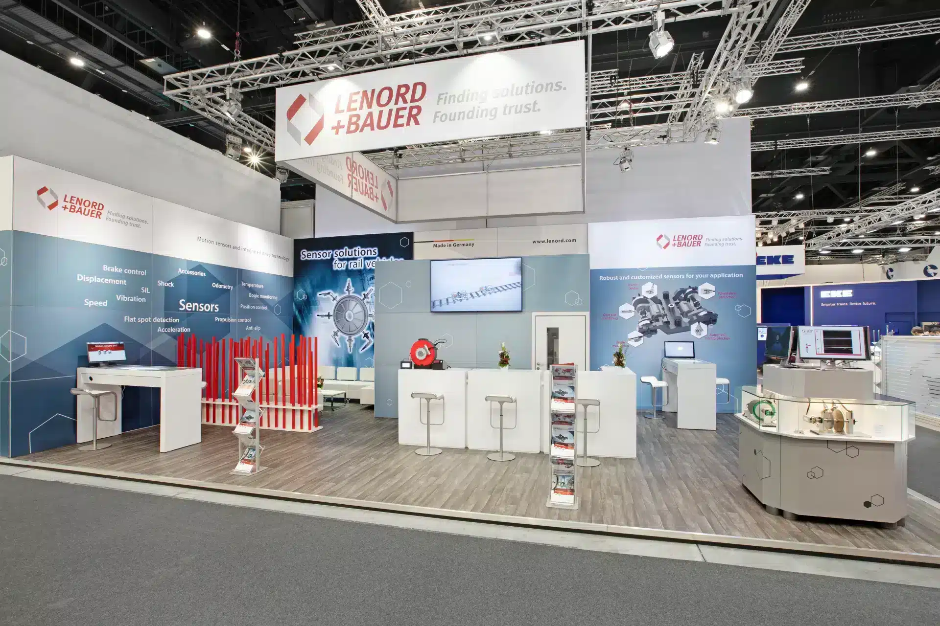Moderner Messestand von Lenord + Bauer auf der InnoTrans 2024 in Berlin mit Theke, Monitor und Sensor-Exponaten.