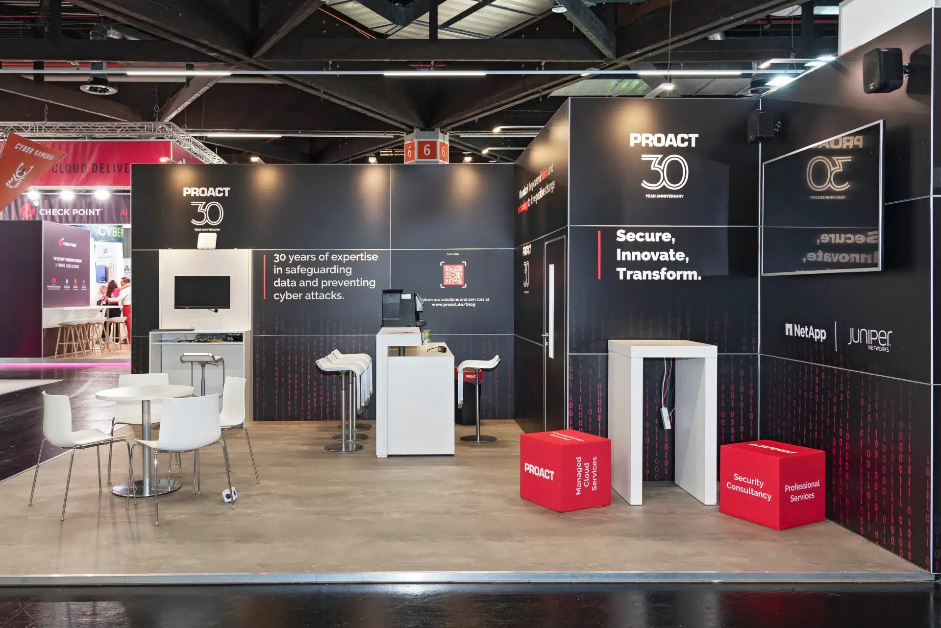 Proact Messestand auf der it-sa 2024 in Nürnberg mit Jubiläumslogo „30 Years Anniversary“, Slogan „Secure, Innovate, Transform“ und Partnern NetApp und Juniper, Messebau Nürnberg.