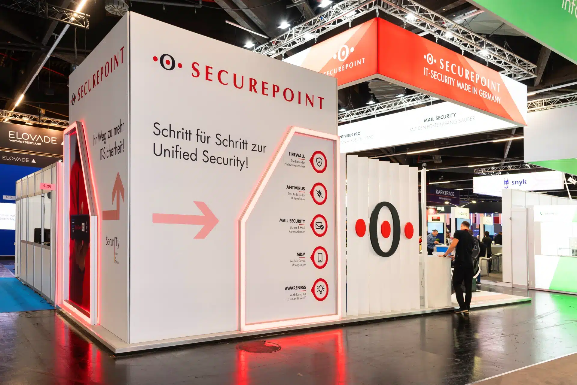 Rückseite des Securepoint Messestands auf der it-sa 2024 in Nürnberg mit roten LED-Elementen und Unified Security Darstellung. Messebau Nürnberg.