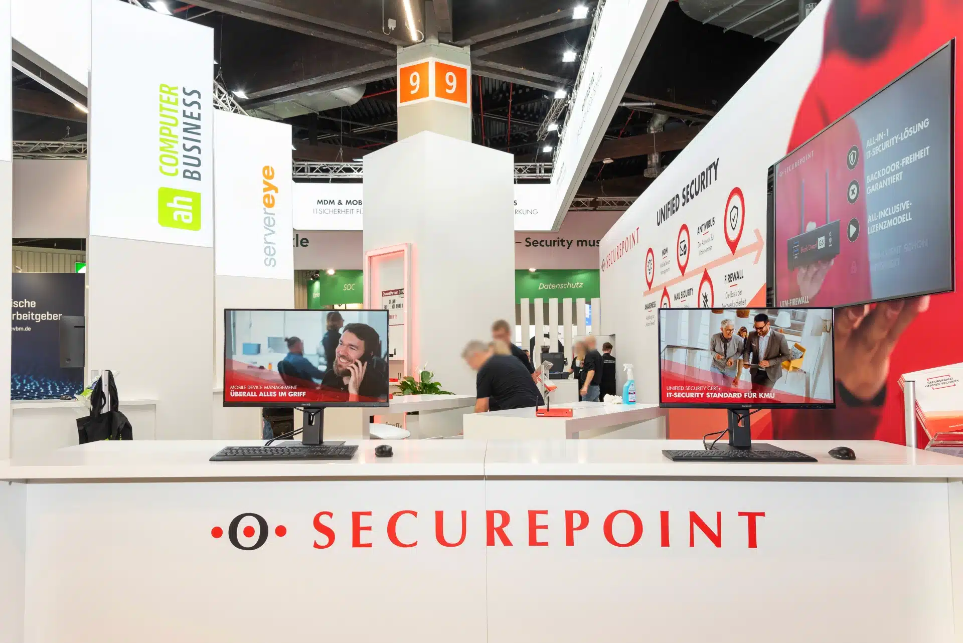 Empfangsbereich von Securepoint auf der it-sa 2024 in Nürnberg mit Monitoren und Unified Security Präsentation. Messebau Nürnberg.