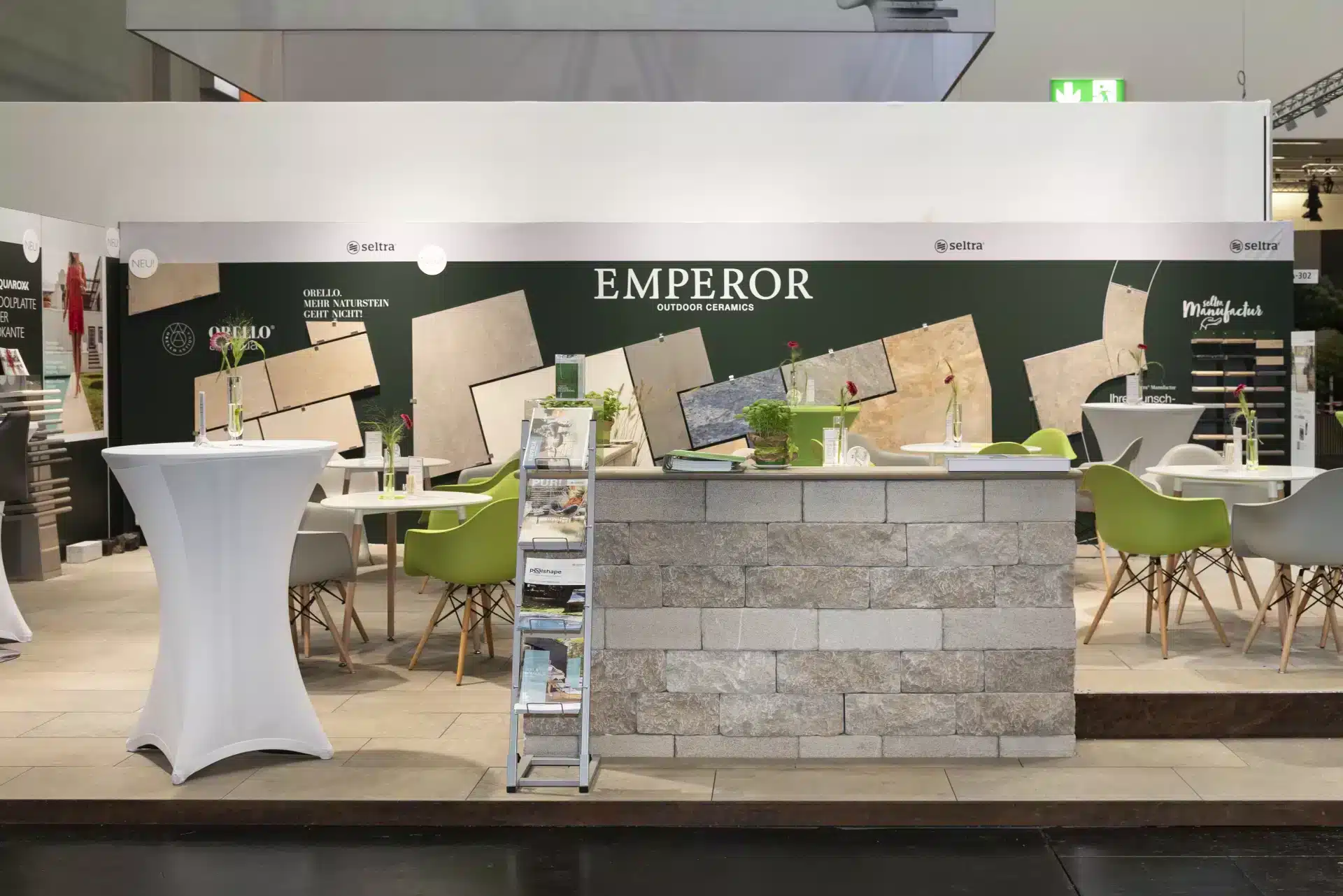 Sitz- und Beratungsbereich am Seltra Messestand mit Natursteinplatten und Präsentationswänden