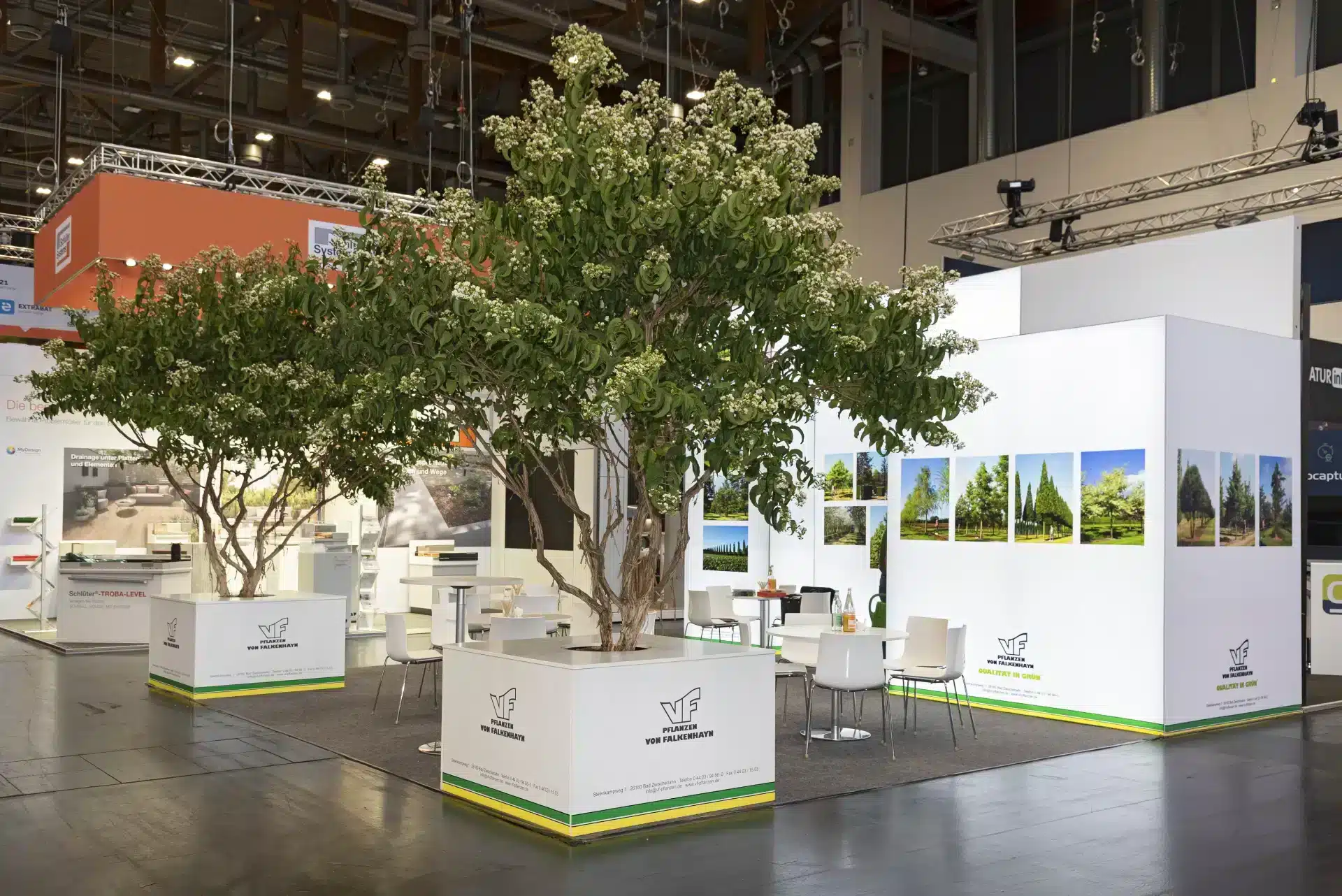 Messebau Nürnberg – Messestand mit großen grünen Bäumen und Sitzbereich, GalaBau Messe 2024.