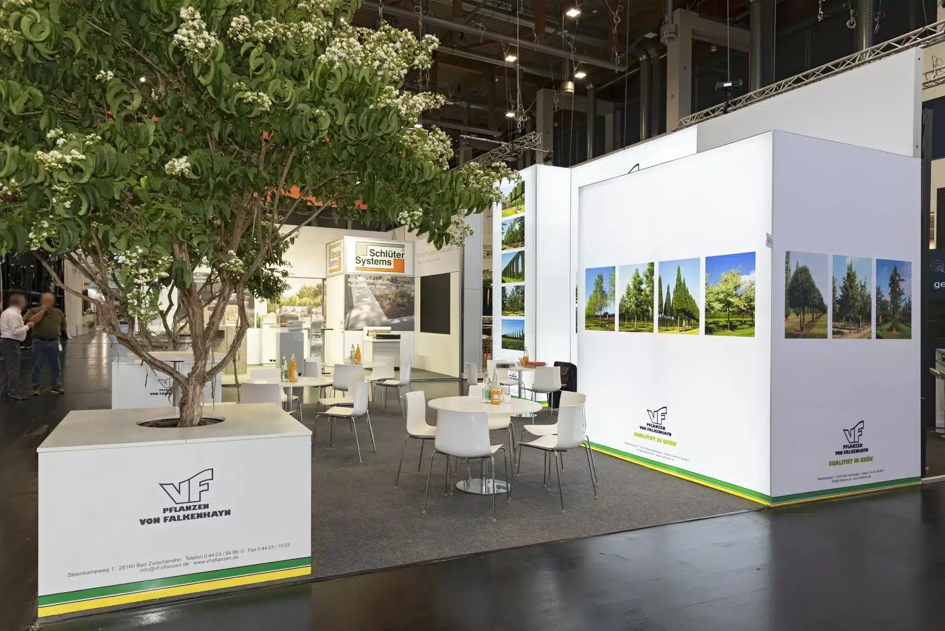 Messebau Nürnberg – Begrünter Messestand mit großem Baum und weißen Sitzmöbeln, GalaBau Messe.