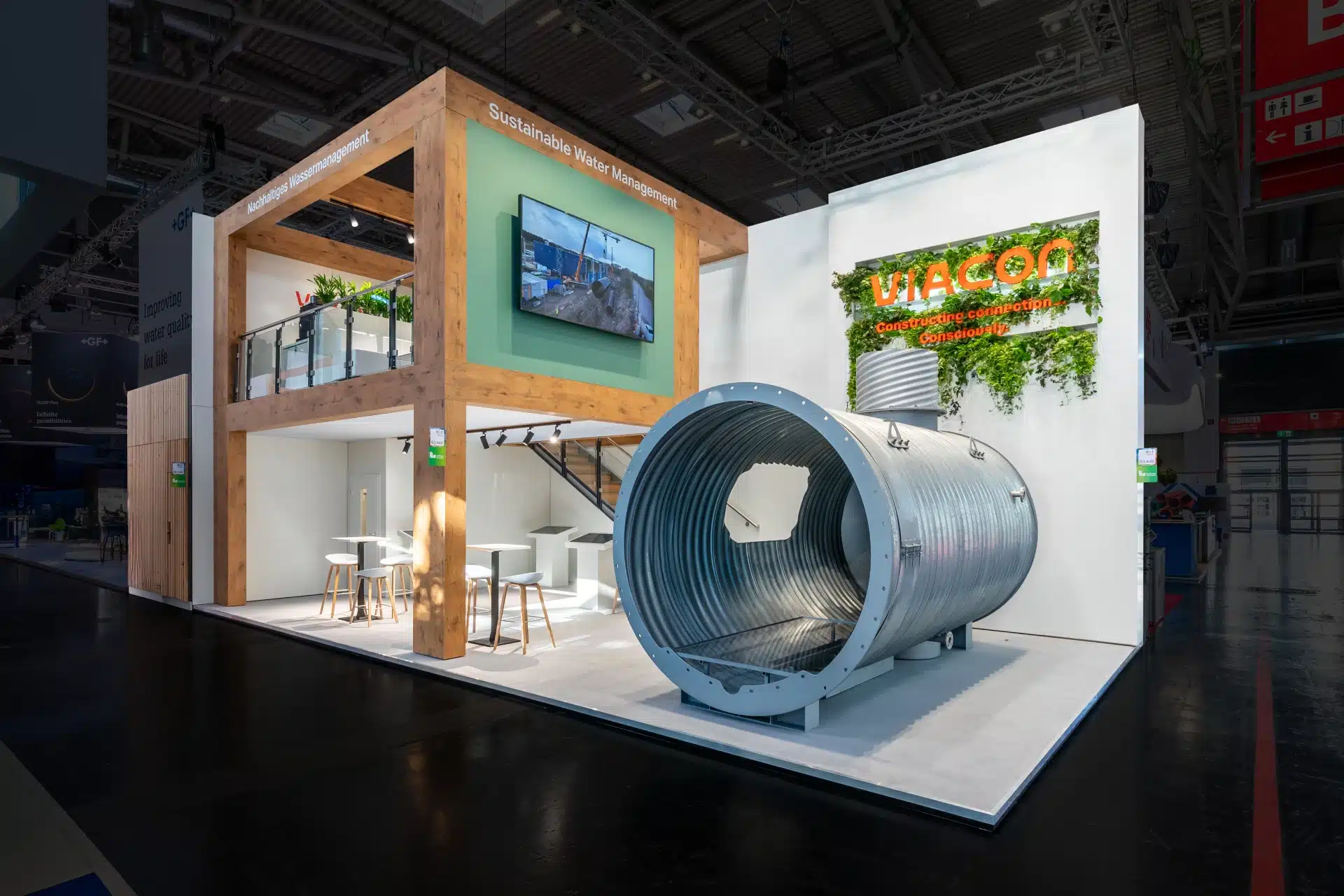 Messestand Viacon auf der IFAT 2024 in München mit großem Stahlrohr, Holzrahmen und nachhaltigem Design