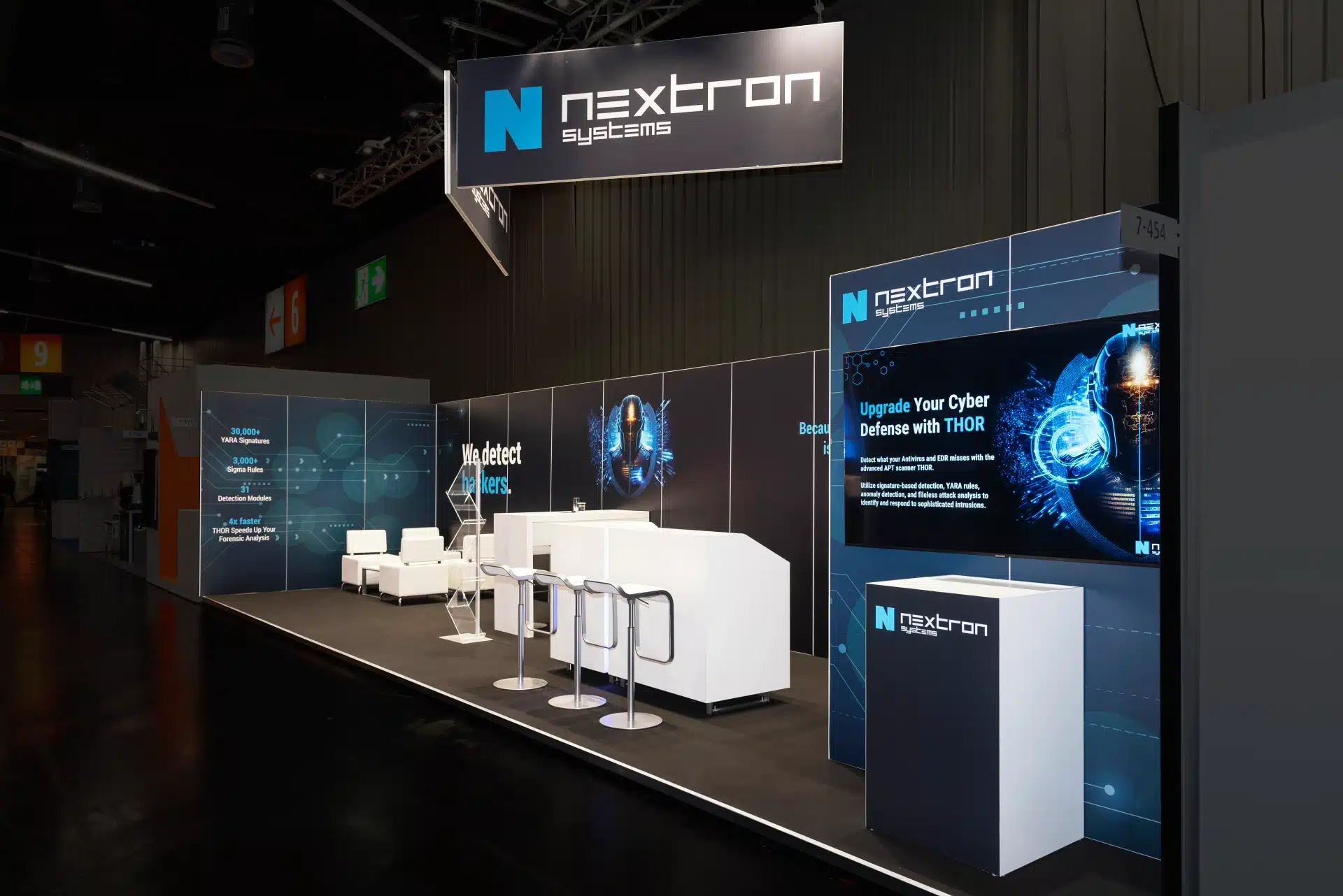 Breite Ansicht des Nextron Systems Stands auf der it-sa 2024 in Nürnberg mit LED-Displays und Cyber-Security-Branding.