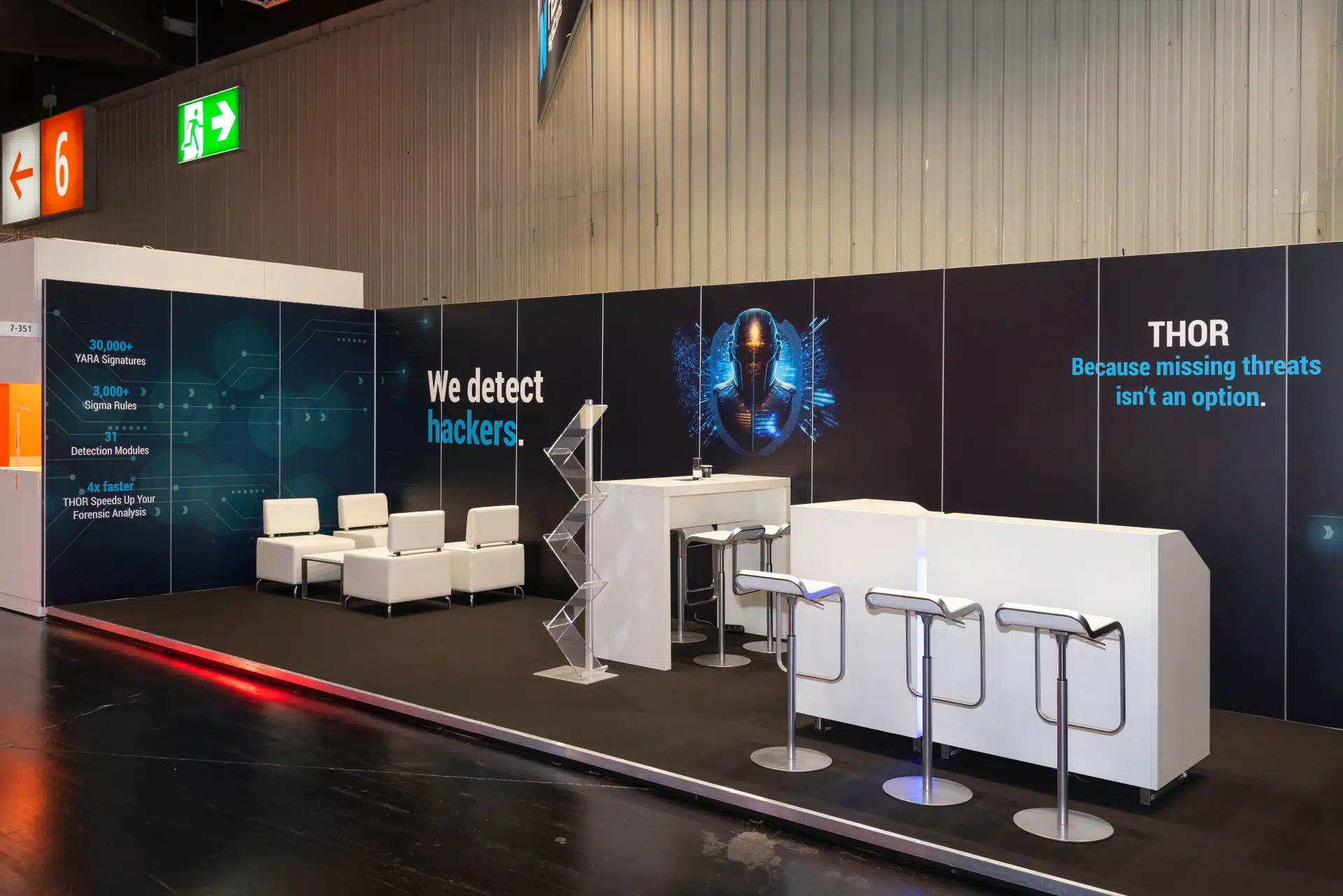 Messeauftritt von Nextron Systems auf der it-sa 2024 in Nürnberg mit Lounge-Bereich, weißen Sitzmöbeln und Slogan „We detect hackers“.