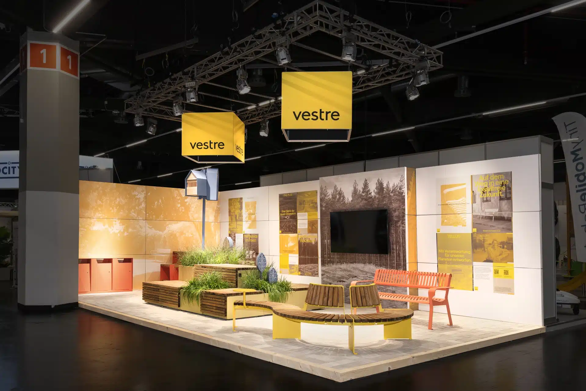 Moderner Messestand von Vestre mit gelben Sitzmöbeln, Pflanzmodulen und LED-Würfeln auf der GalaBau in Nürnberg – Messebau Nürnberg.