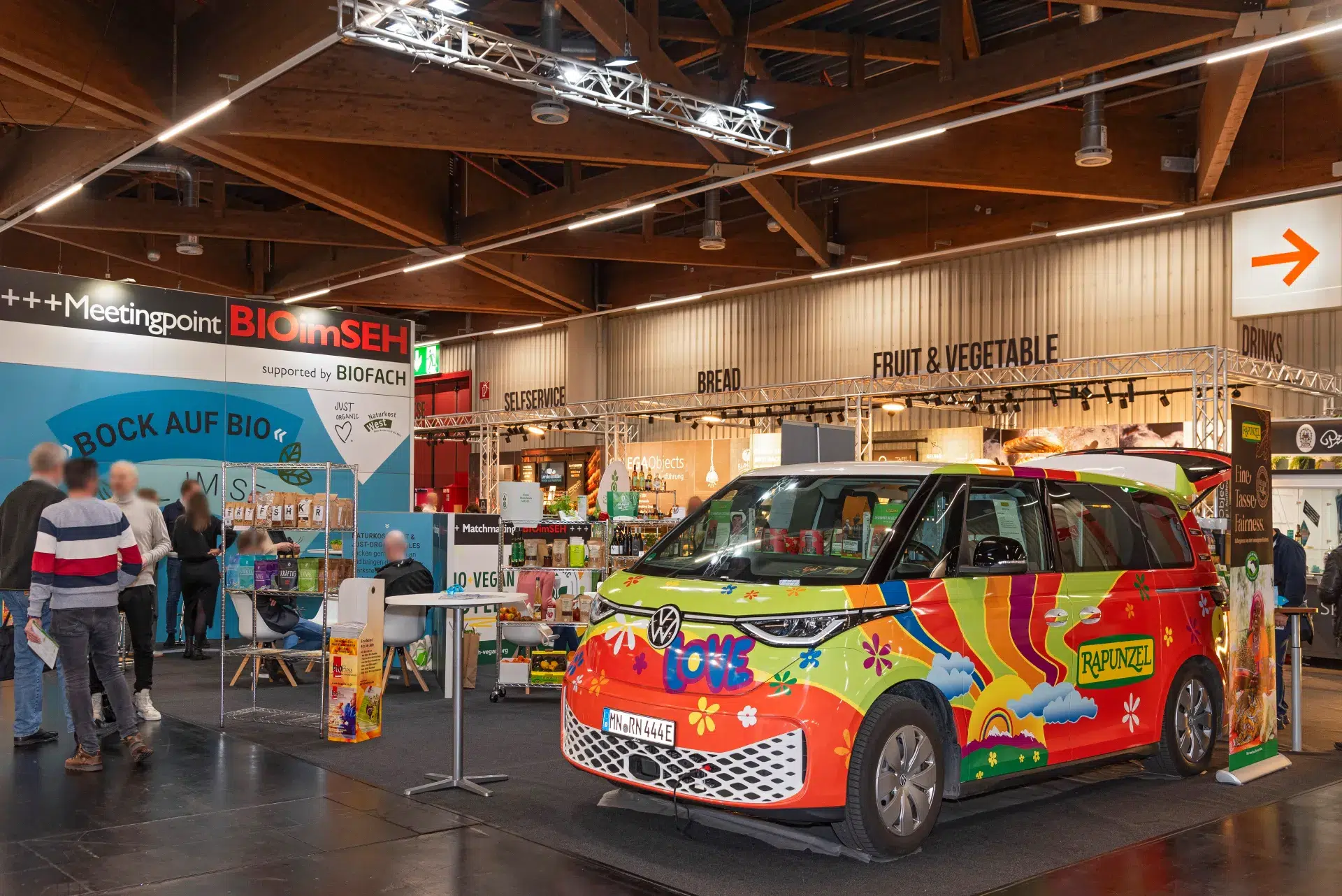 Bunt gestalteter VW Bus „Rapunzel“ vor dem Meetingpoint BIOimSEH auf der BioFach Messe 2025 in Nürnberg.