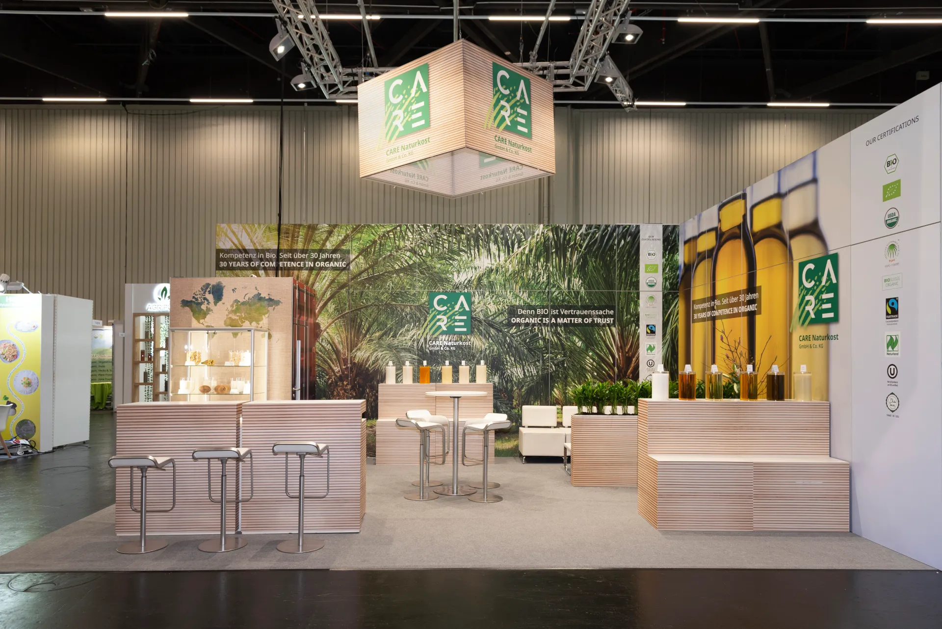 CARE Naturkost Messestand mit Bio-Produkten, Zertifizierungen und modernem Design auf der Biofach Messe 2025 in Nürnberg – Messebau Nürnberg.