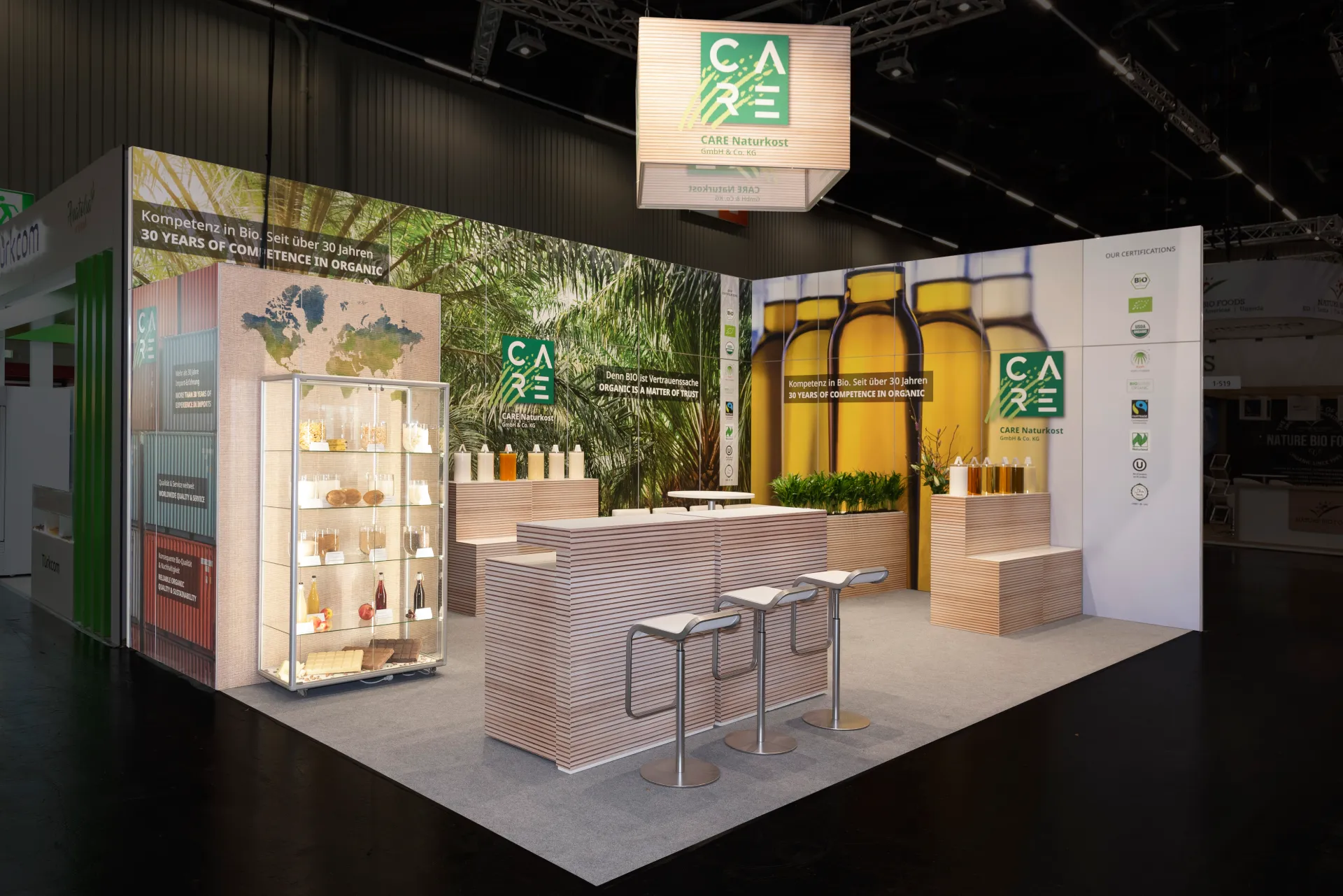 Designorientierter Messestand von CARE Naturkost mit Theke und Sitzgelegenheiten auf der Biofach Messe 2025 in Nürnberg – Messebau Nürnberg.