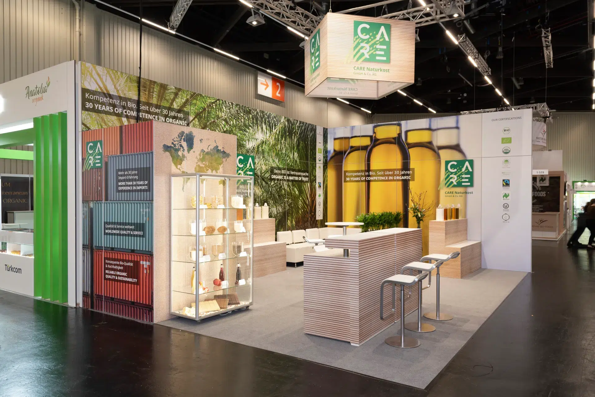 Großzügiger CARE Naturkost Messestand mit Glasvitrine und Bio-Produkten auf der Biofach Messe 2025 in Nürnberg – Messebau Nürnberg.