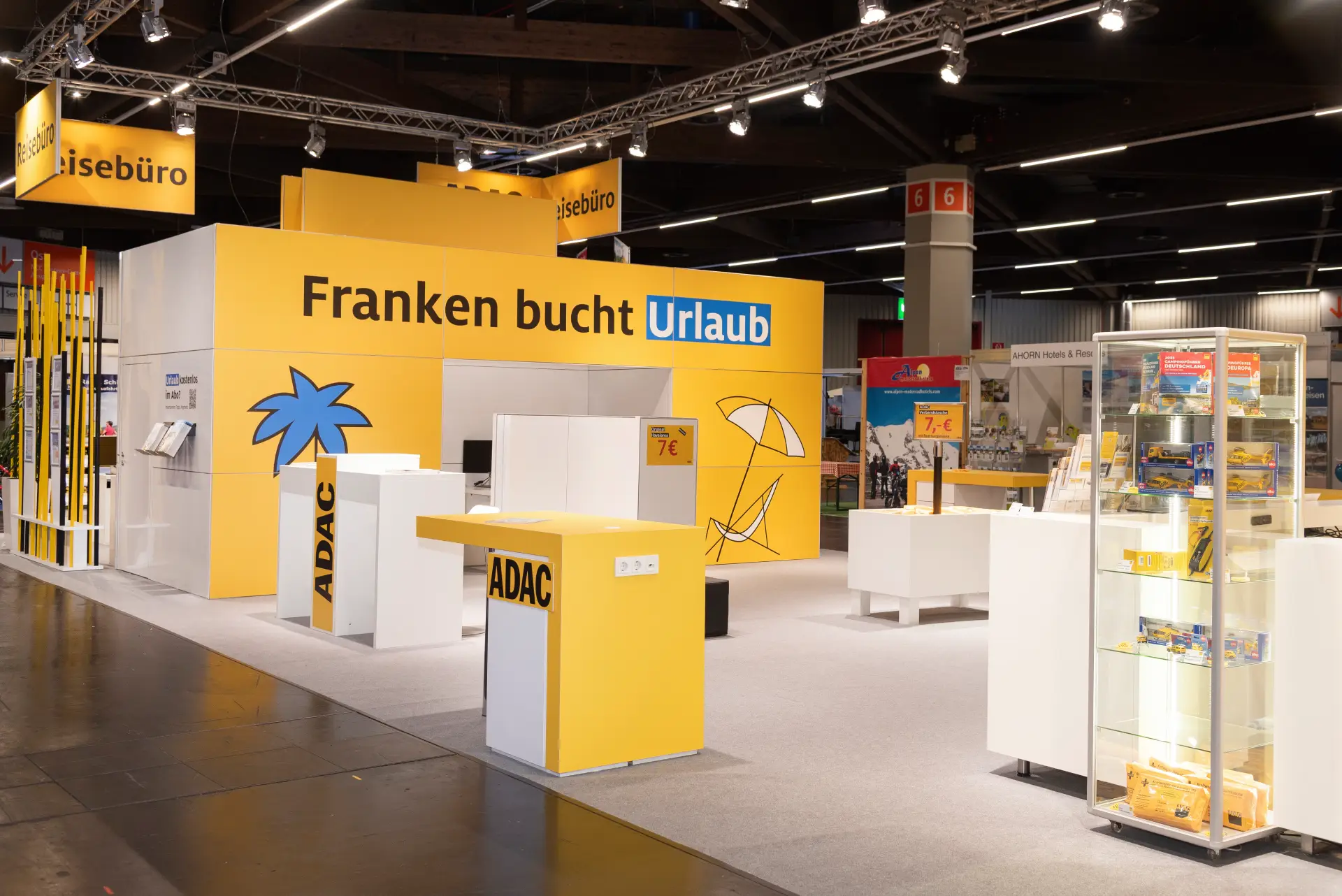 ADAC Messestand mit Urlaubsprospekten und gelbem Design auf der Freizeit Touristik & Garten Messe 2025 in Nürnberg.
