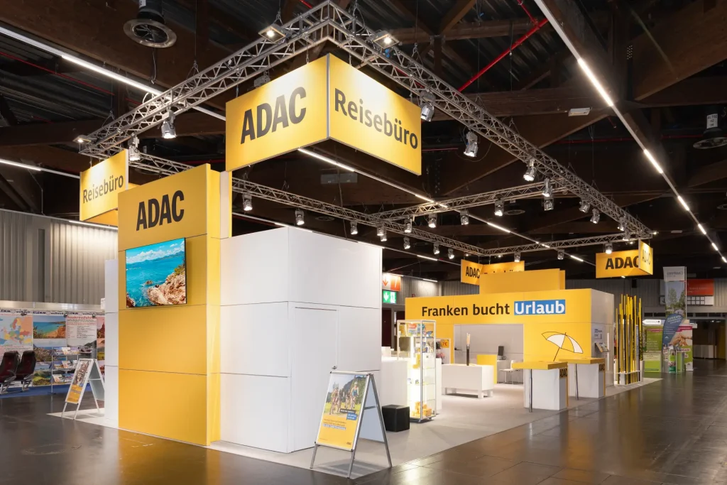 ADAC Messestand mit großen gelben Hängeelementen und Urlaubswelt Präsentation auf der Freizeit Touristik & Garten Nürnberg 2025.