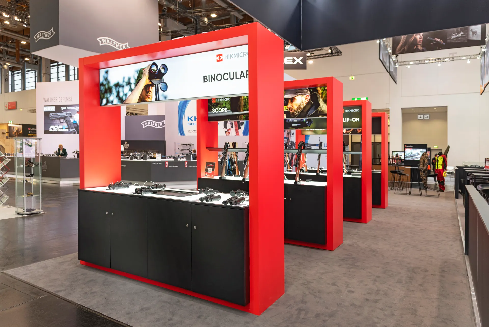 Präsentation von Ferngläsern im rot-schwarzen HIKMICRO Messestand auf der IWA 2025 in Nürnberg – Messebau Nürnberg.