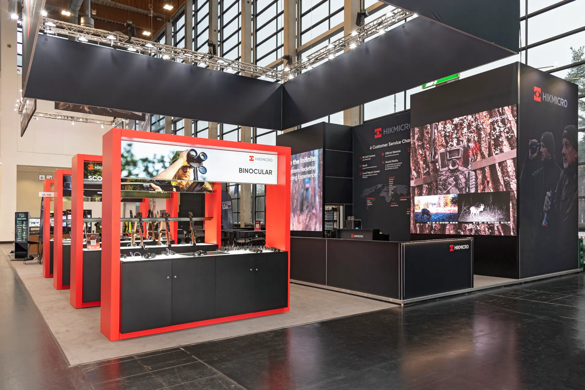 HIKMICRO Messestand mit großflächigen LED-Screens und roten Ausstellungsmodulen auf der IWA 2025 in Nürnberg – Messebau Nürnberg.