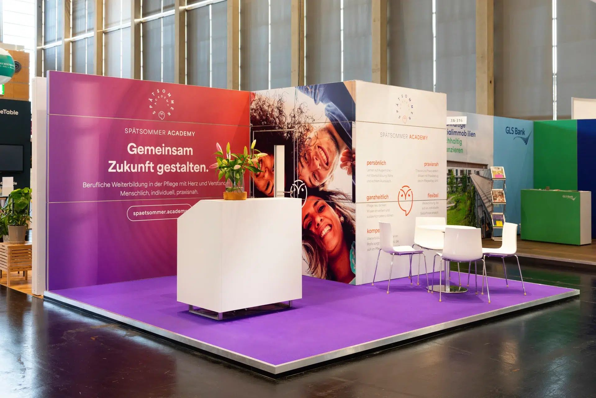 Messebau Nürnberg – moderner Spätsommer Academy Messestand mit Fokus auf praxisnahe Pflegeweiterbildung auf der Altenpflegemesse 2025.