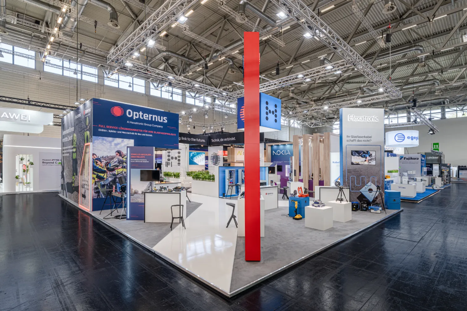 Messebau Köln – moderner Messestand von Opternus und Hexatronic auf der AngaCom 2025 in Köln mit klarer Architektur und Technikpräsentation.