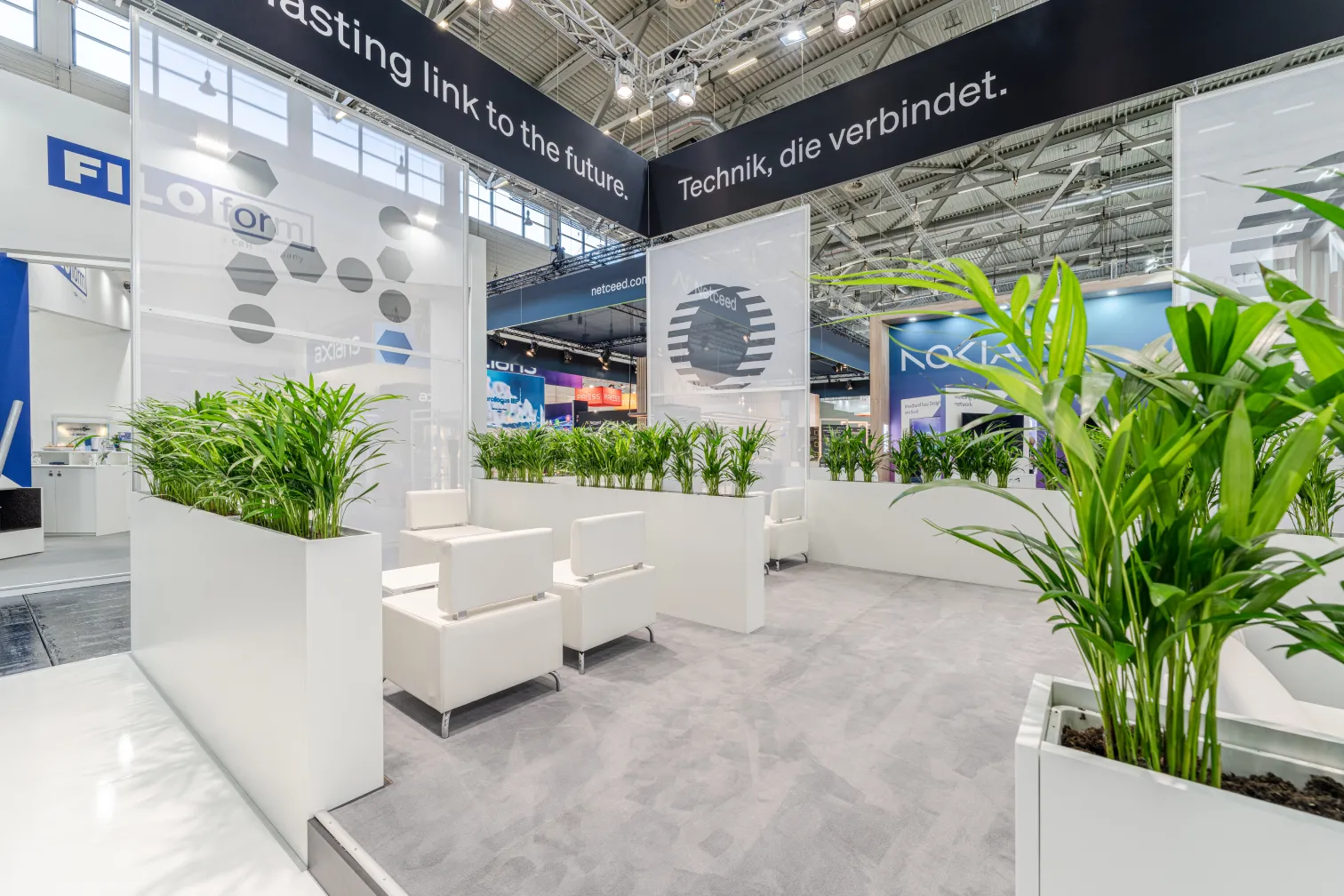 Messebau Köln – moderner Hexatronic Messestand auf der AngaCom 2025 mit Barbereich und Sitzlounge.