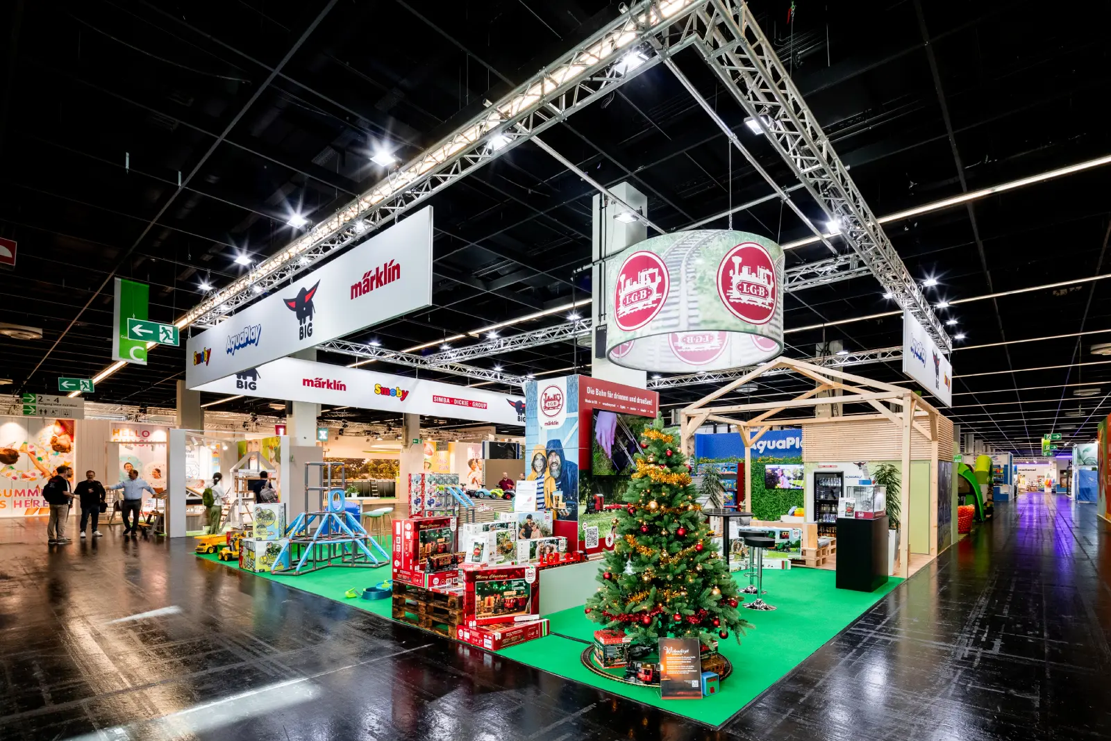 Messebau Köln – Messestand mit Weihnachtsbaum, LGB Modelleisenbahn, AquaPlay Spielwelten und Markenpräsentationen auf der Messe in Köln.