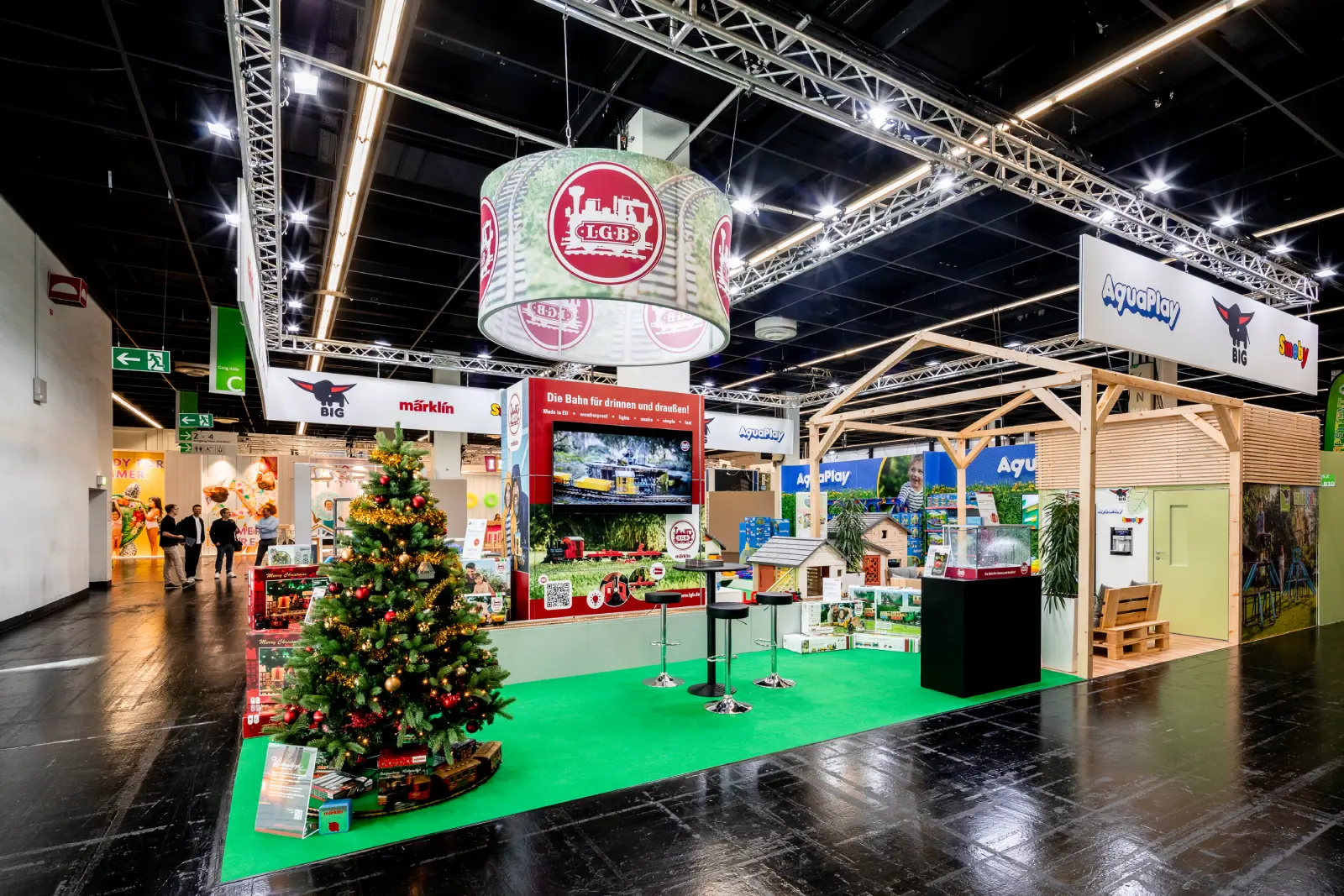Messebau Köln – festlich dekorierter Messestand mit Weihnachtsbaum, LGB Modelleisenbahn und AquaPlay Ausstellung auf der Messe in Köln.
