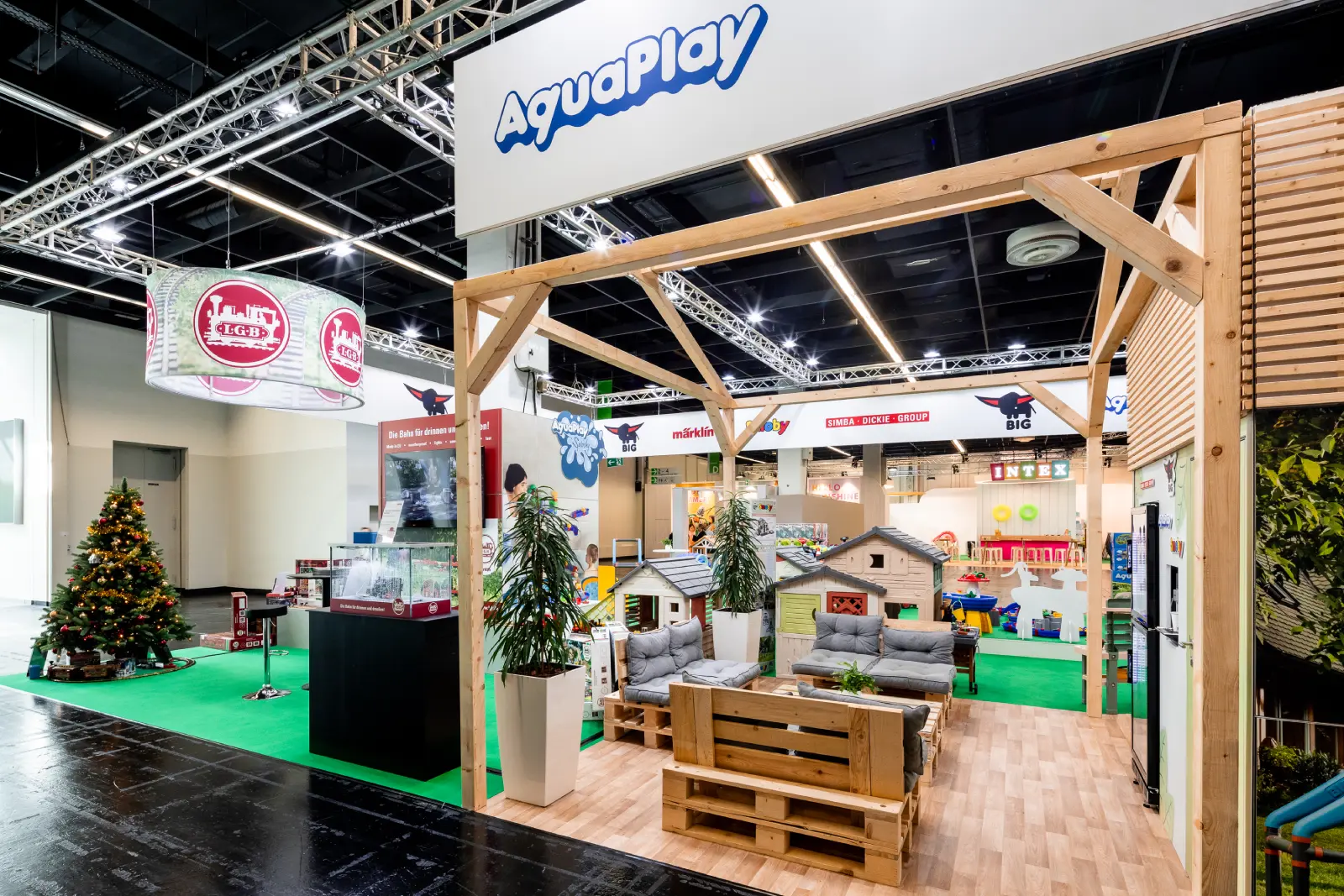Moderner Messestand mit Holz- und Lounge-Elementen auf der Messe Köln – professioneller Messebau mit AquaPlay Ausstellung.